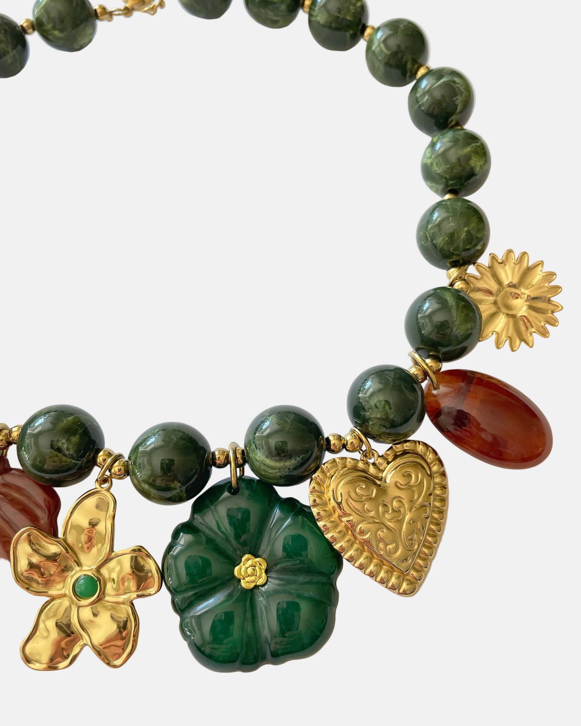 Χειροποίητο γυναικείο κολιέ με πράσινες χάντρες, χρυσά στοιχεία και μενταγιόν φύλλο, λουλούδι και καρδιά