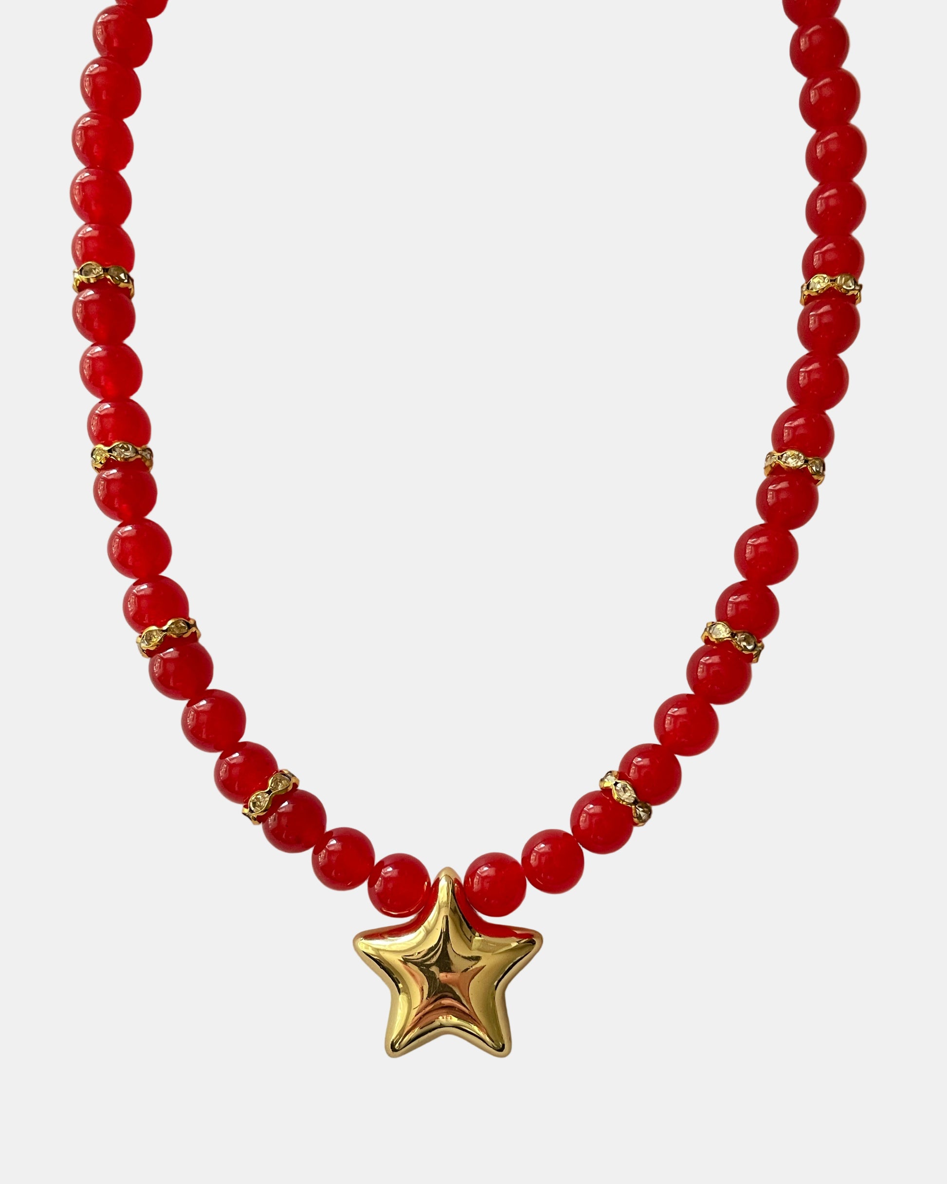 Χειροποίητο κόκκινο κολιέ με χρυσές λεπτομέρειες και χρυσό μεταλλικό στοιχείο σε σχήμα αστεριού στο κέντρο.