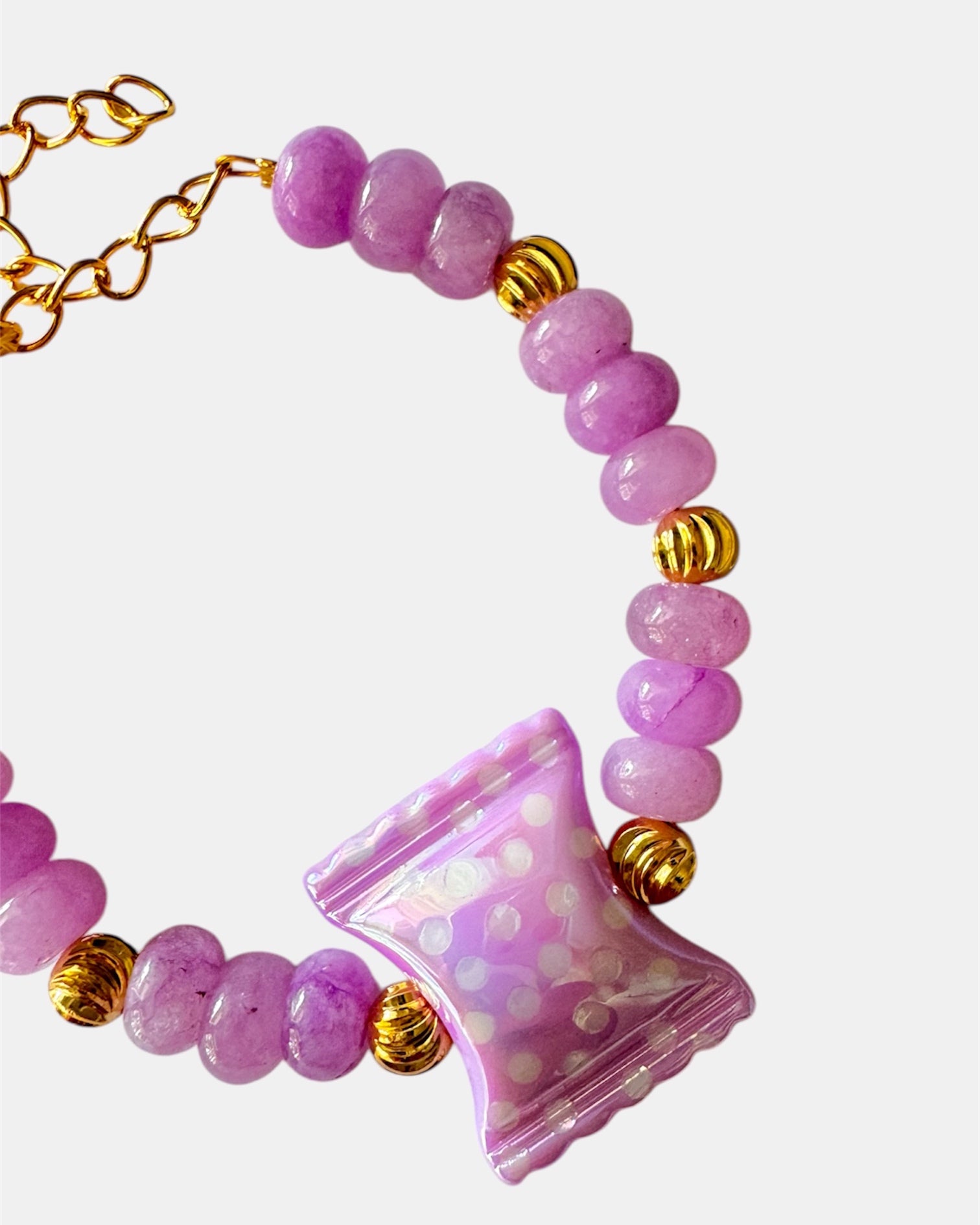 Lilac beaded bracelet featuring a ceramic candy charm for a playful, colorful look