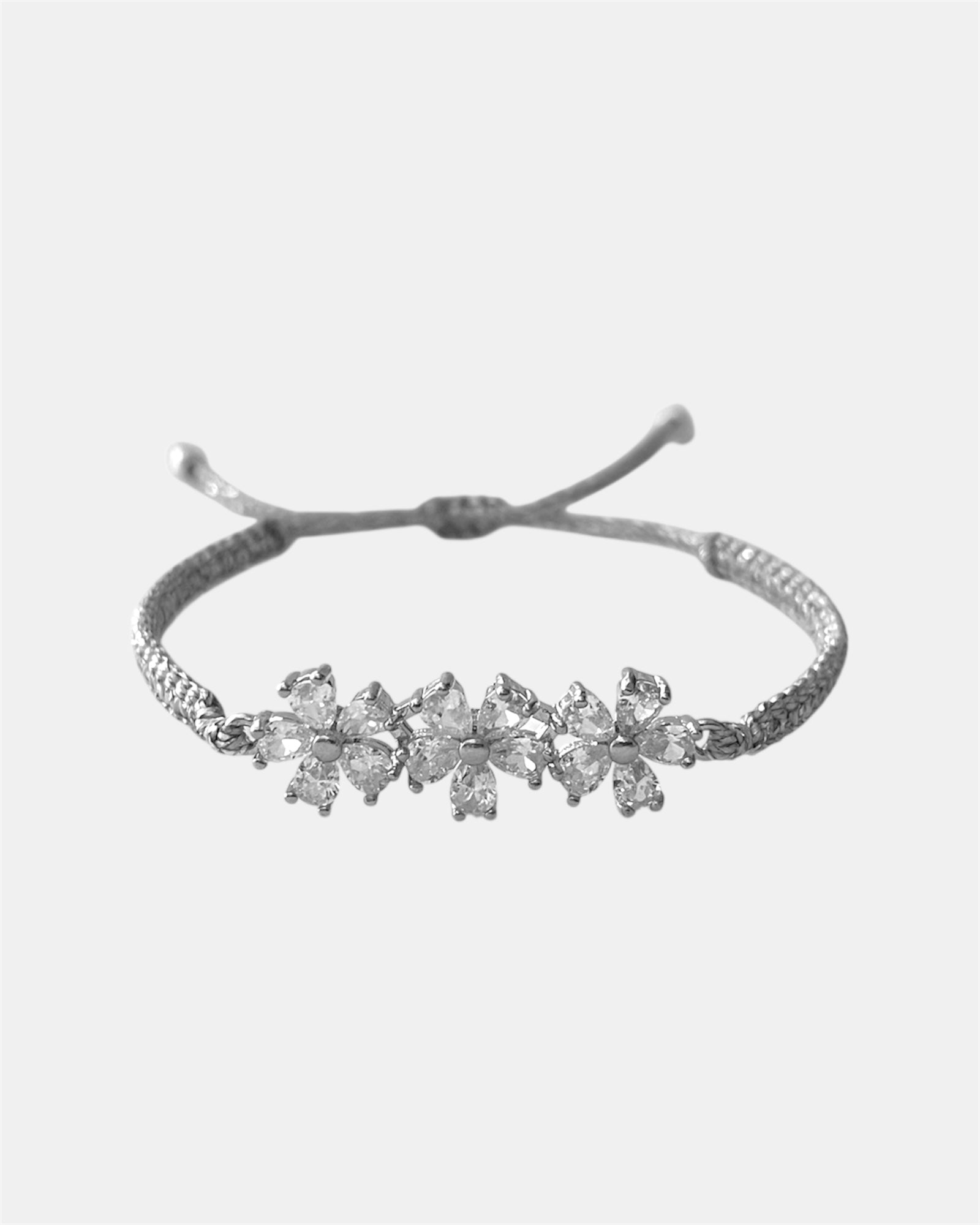 Μακραμέ ασημί βραχιόλι με λουλούδια από λευκά ζιργκόν σε φόντο λευκό