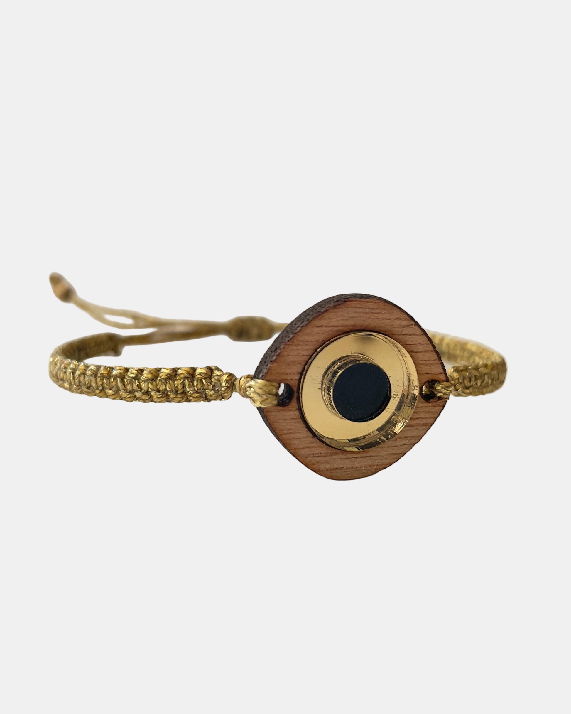 Χειροποίητο μακραμέ βραχιόλι με χρυσό κορδόνι και ξύλινο στοιχείο ματιού με μαύρη λεπτομέρεια