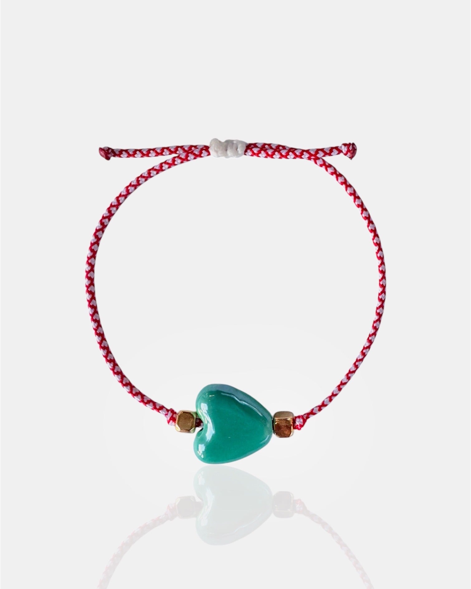 Χειροποίητο μαρτάκι με τιρκουάζ κεραμική καρδιά και χρυσές λεπτομέρειες, βραχιόλι Μαρτίου για γυναίκα.