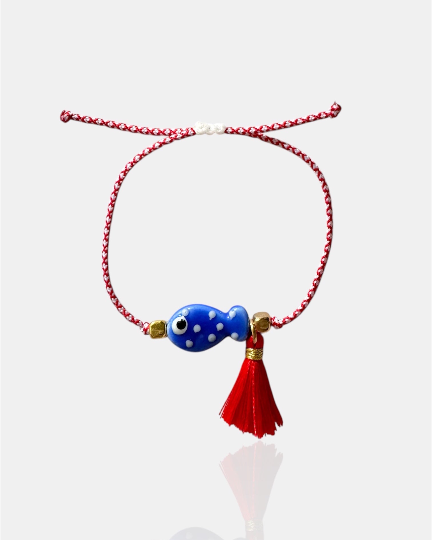 Χειροποίητο μαρτάκι με μπλε γυάλινο ψαράκι και κόκκινη φούντα σε κόκκινο-λευκό κορδόνι