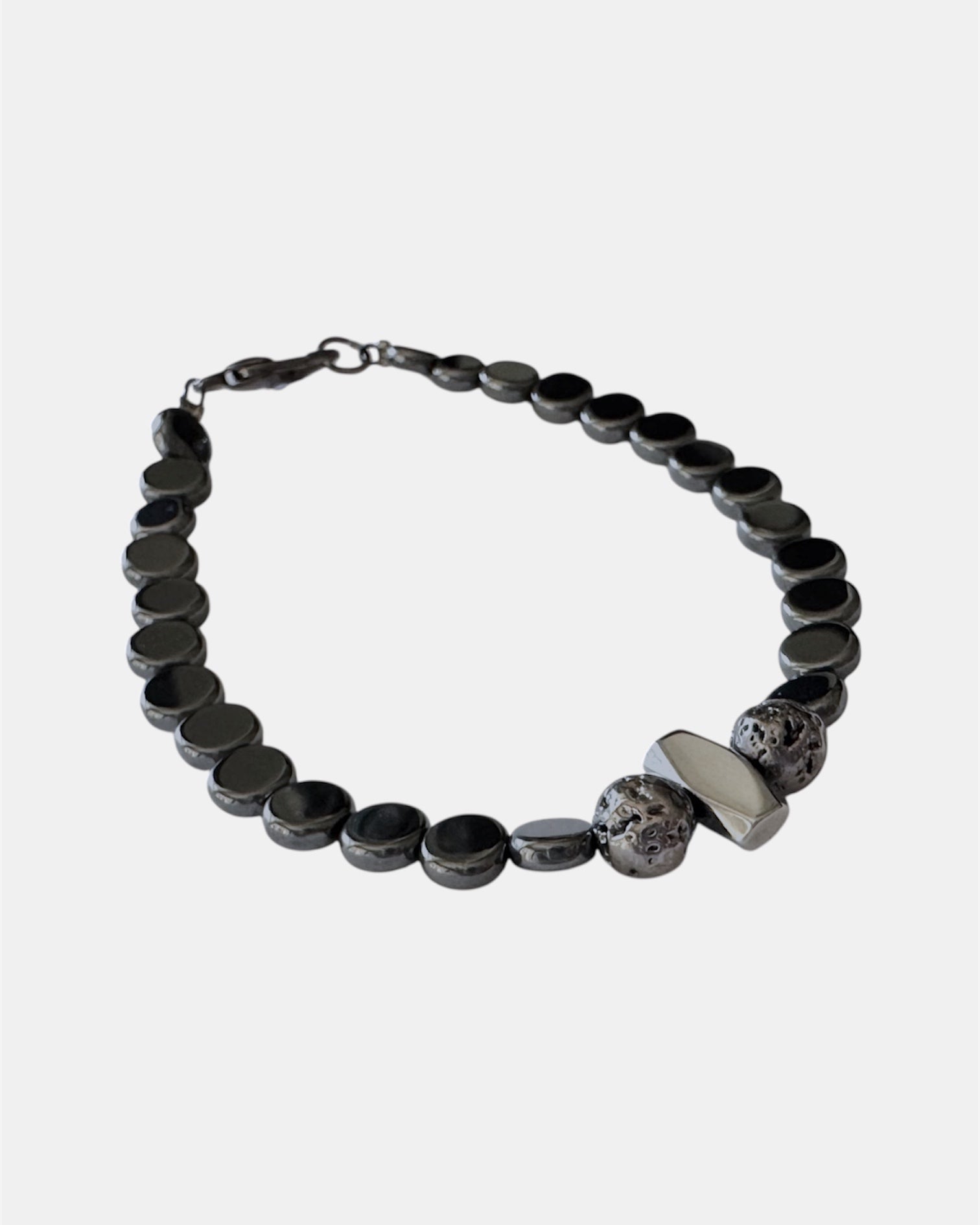 Μαύρο βραχιόλι με χάντρες αιματίτη και μεταλλικό στοιχείο, γυναικείο χειροποίητο κόσμημα.