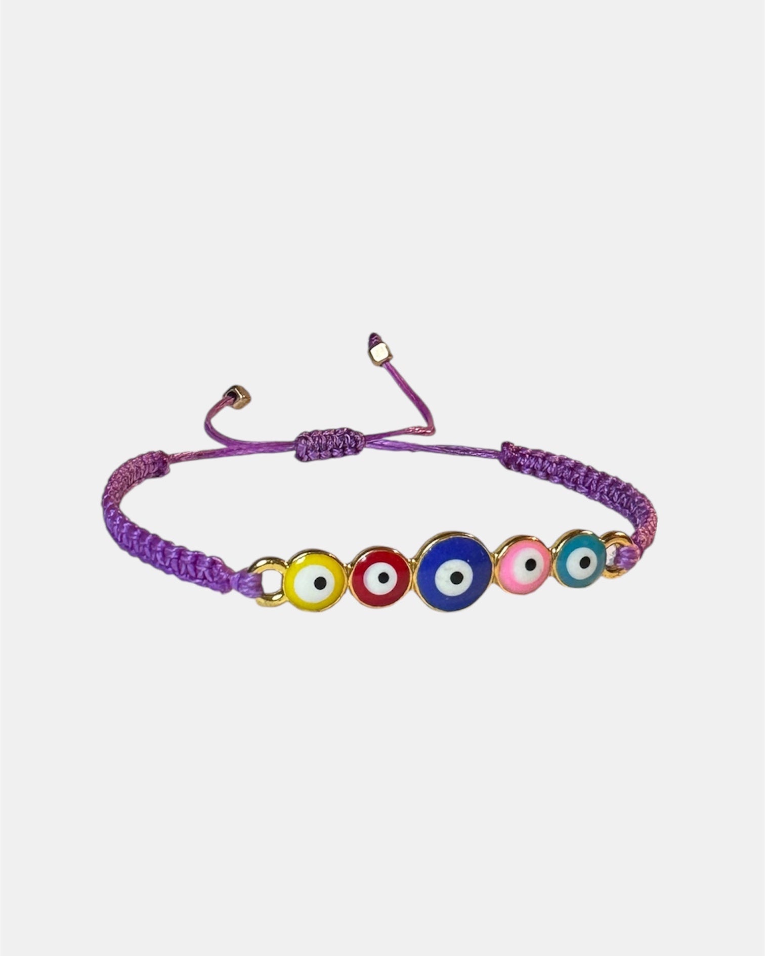 Bracelet with colorful evil eye beads on a light purple cord against a white background