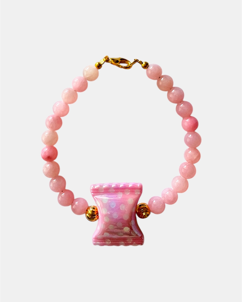 Pink beaded bracelet featuring a candy-shaped charm for a playful and sweet look