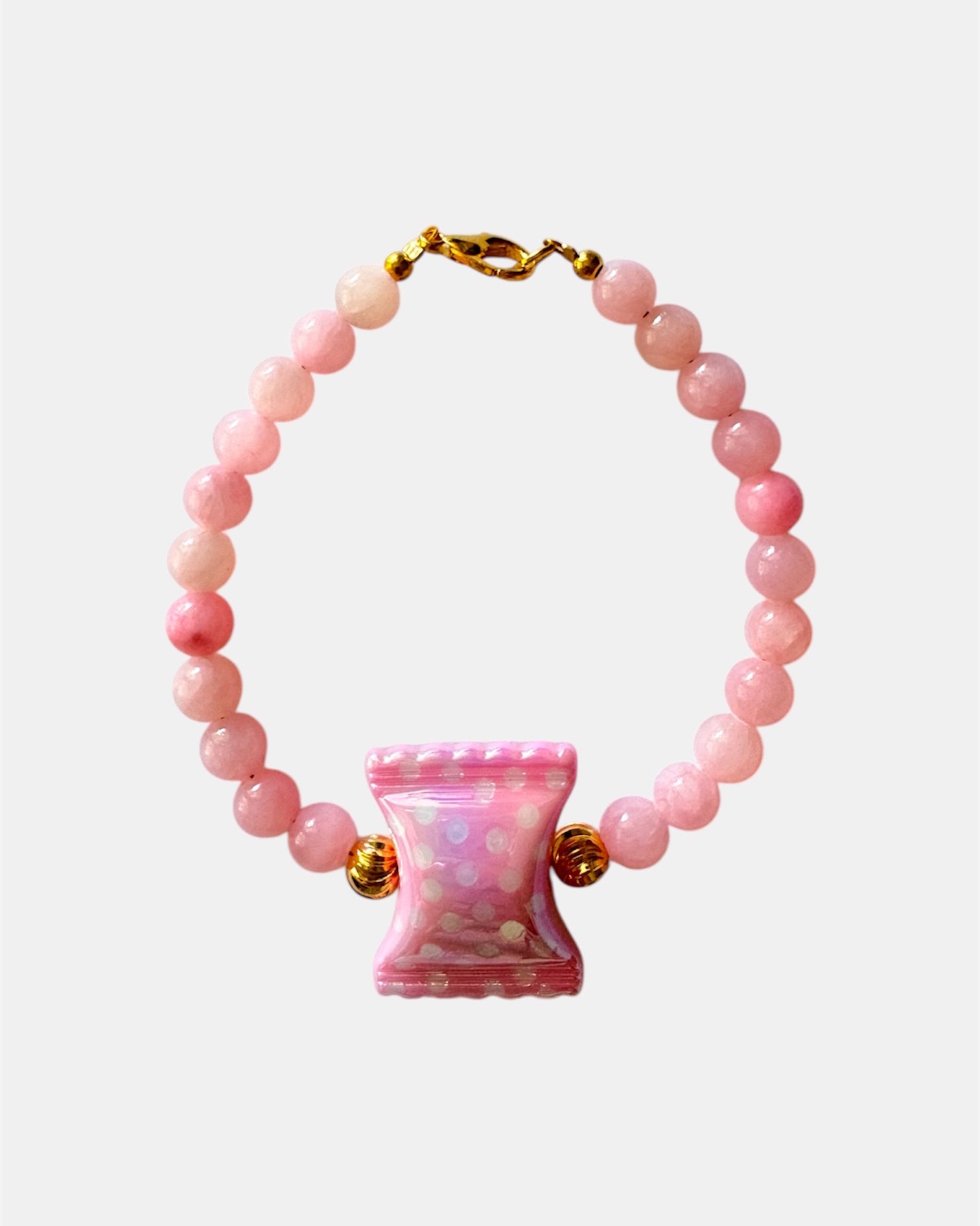 Pink beaded bracelet featuring a candy-shaped charm for a playful and sweet look
