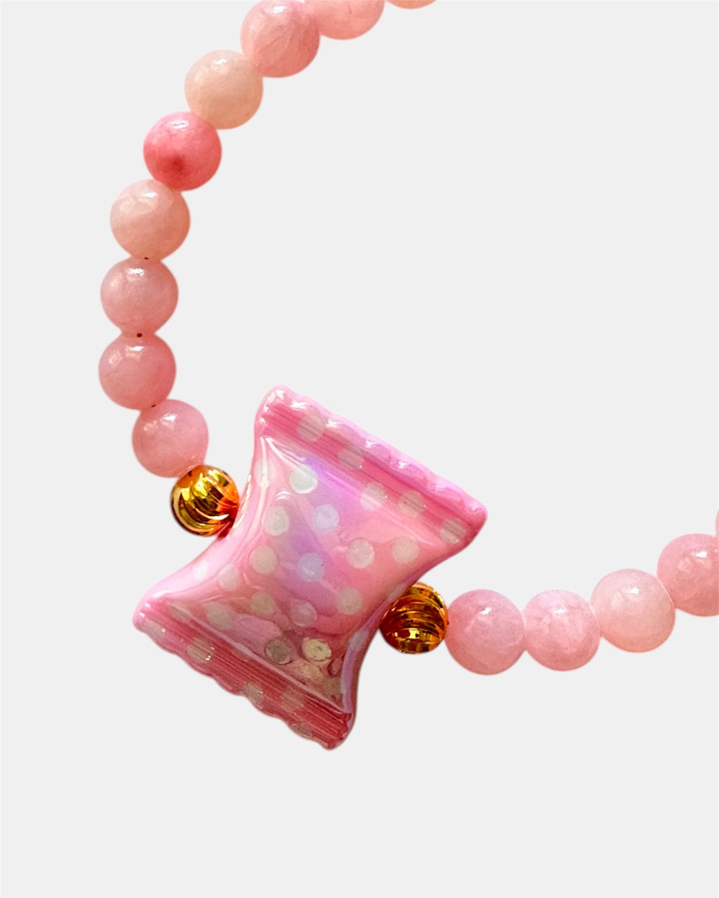 Pink beaded bracelet featuring a candy-shaped charm for a playful and sweet look