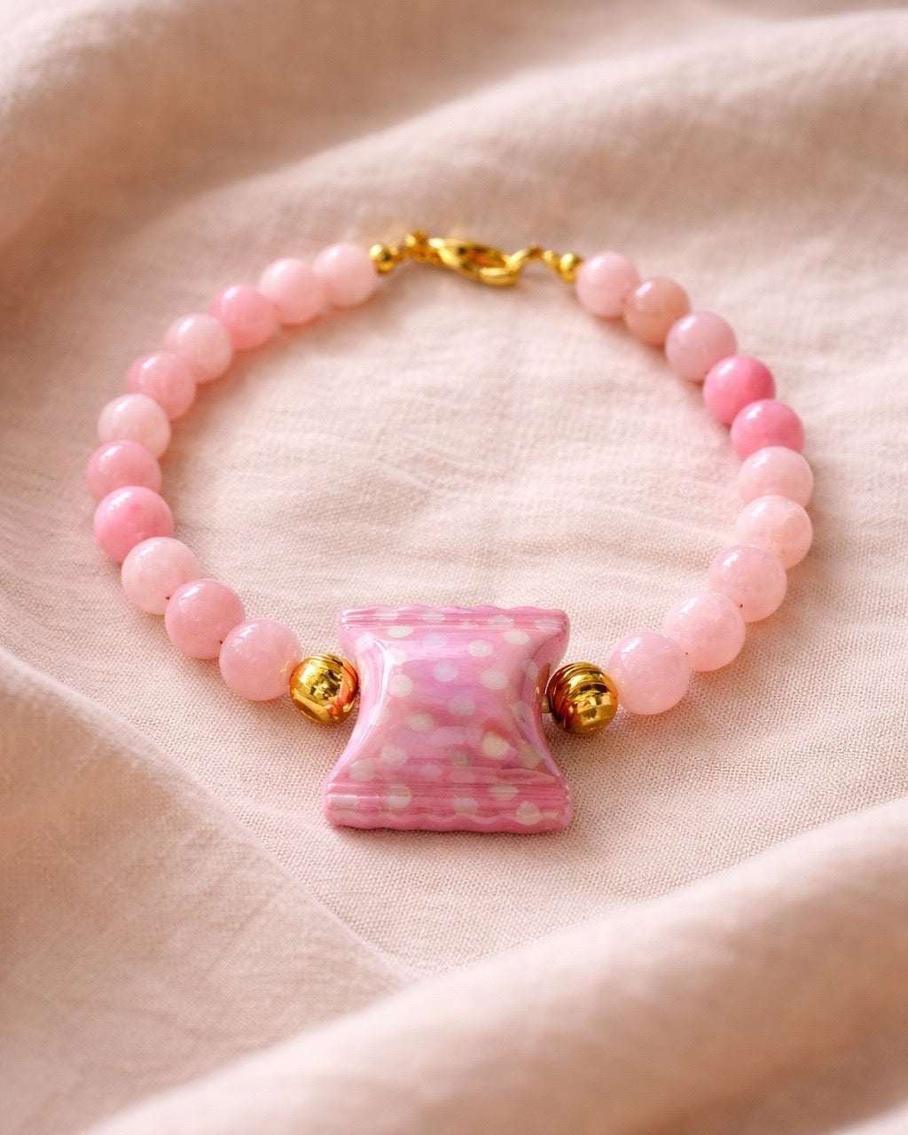 Pink beaded bracelet featuring a candy-shaped charm for a playful and sweet look