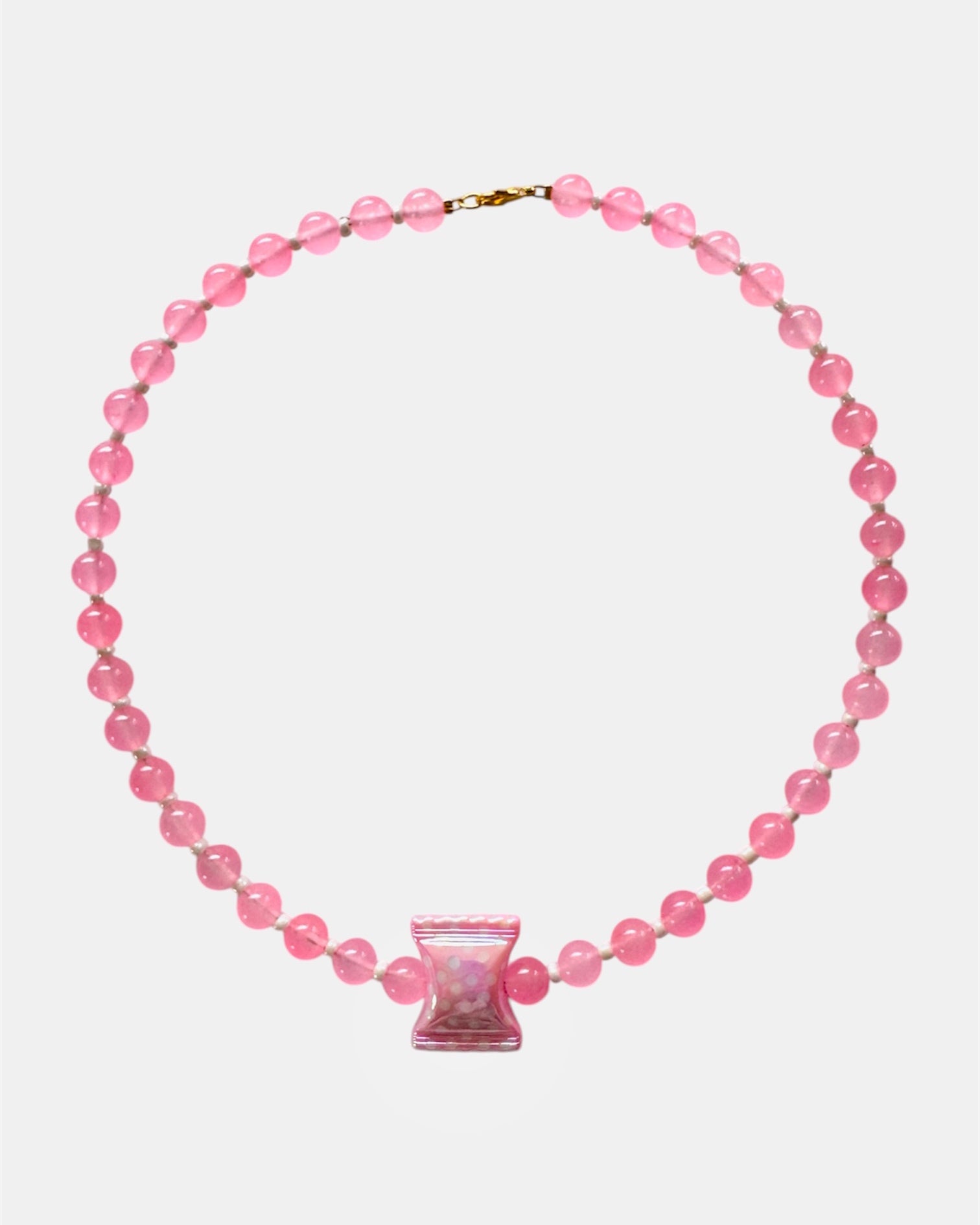 Pink beaded necklace with a pink clasp on a white background