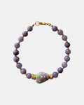 Purple beaded bracelet with a ceramic strawberry charm