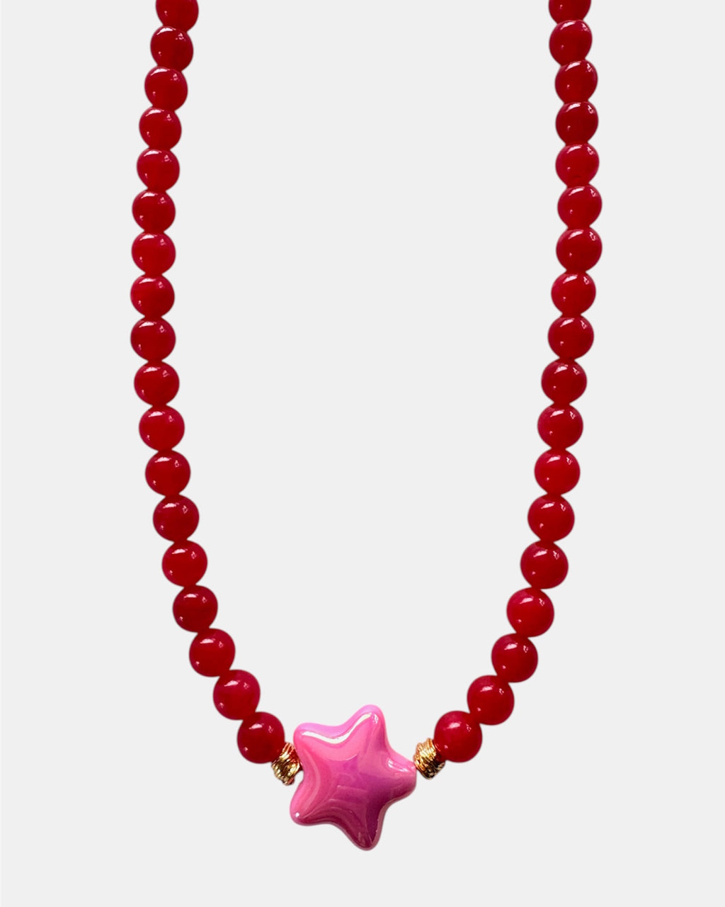Beaded necklace with a pink star-shaped pendant on a white background