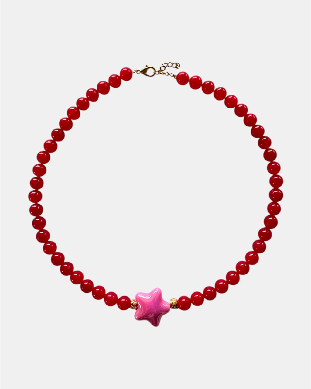 Necklace with red beads and a pink star-shaped charm on a white background