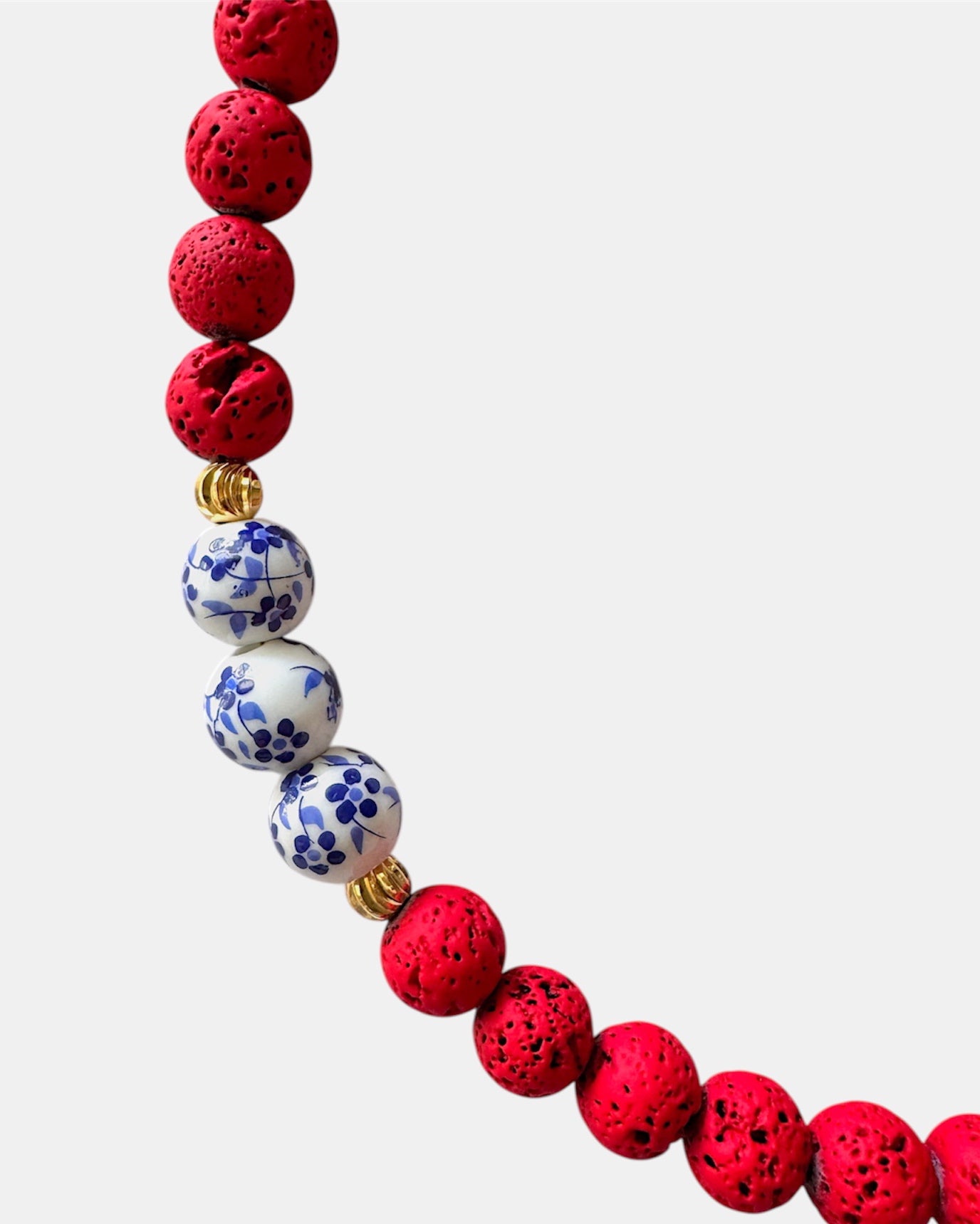 Bold red necklace with lava beads and porcelain elements, unique handmade jewelry with natural textures and modern design