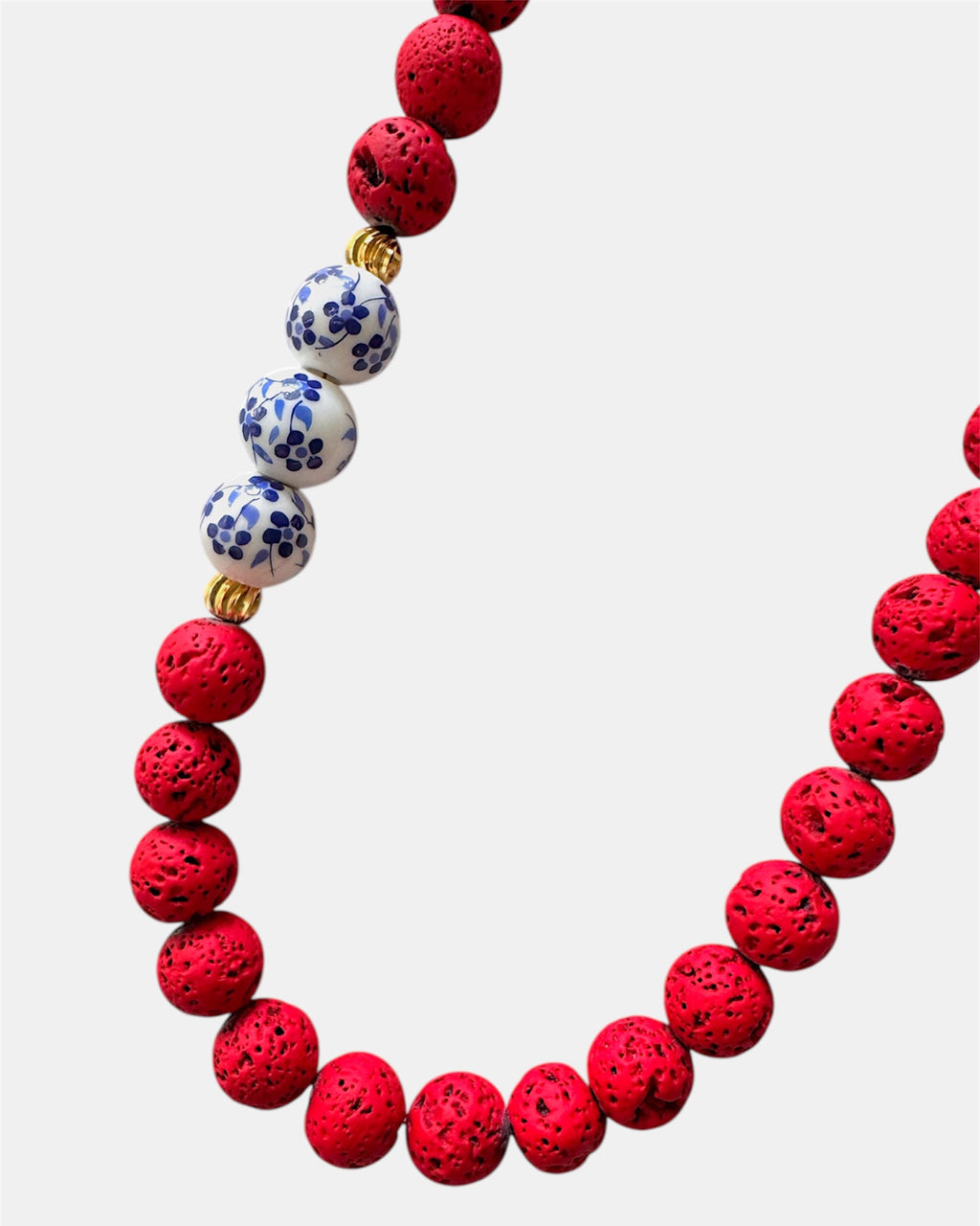Bold red necklace with lava beads and porcelain elements, unique handmade jewelry with natural textures and modern design