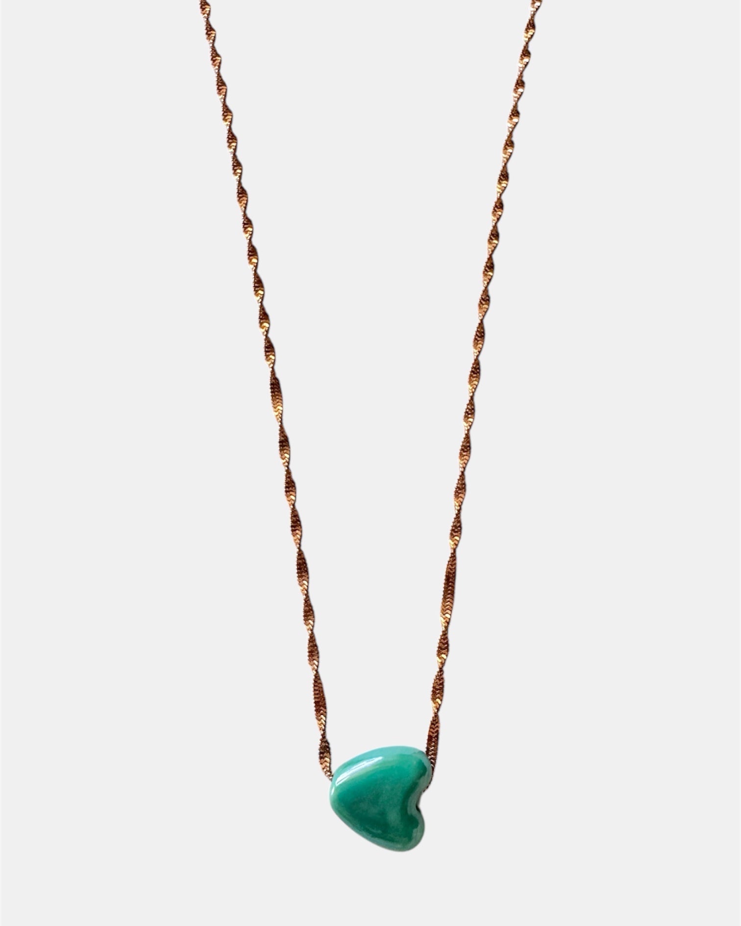 Rose gold chain necklace with a green heart charm
