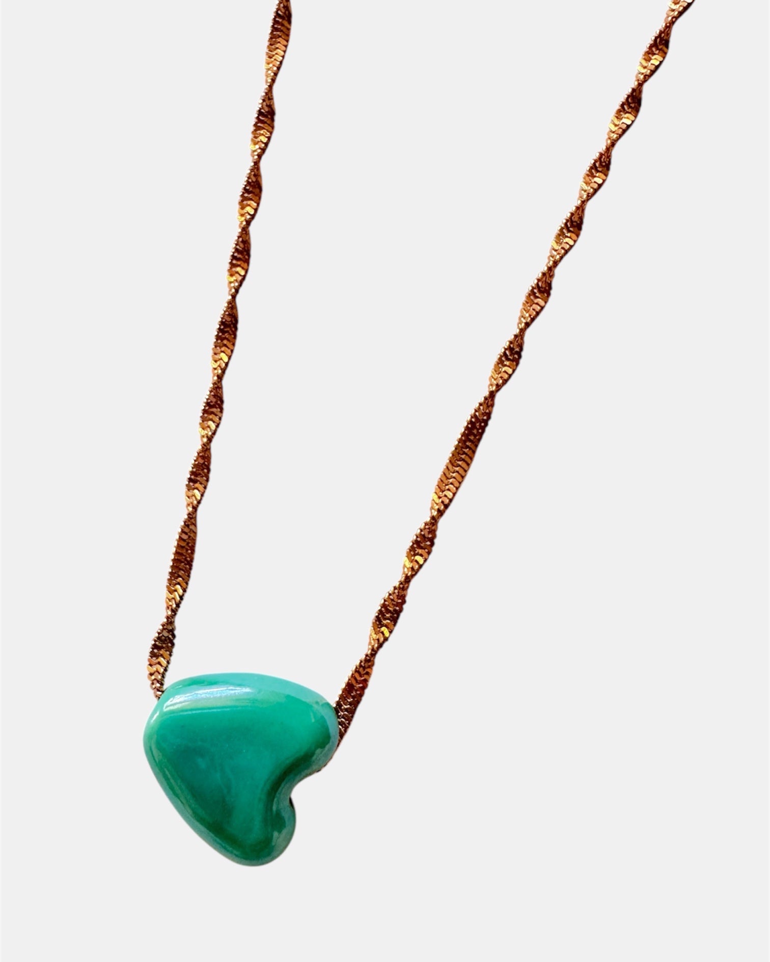 Rose gold chain necklace with a green heart charm