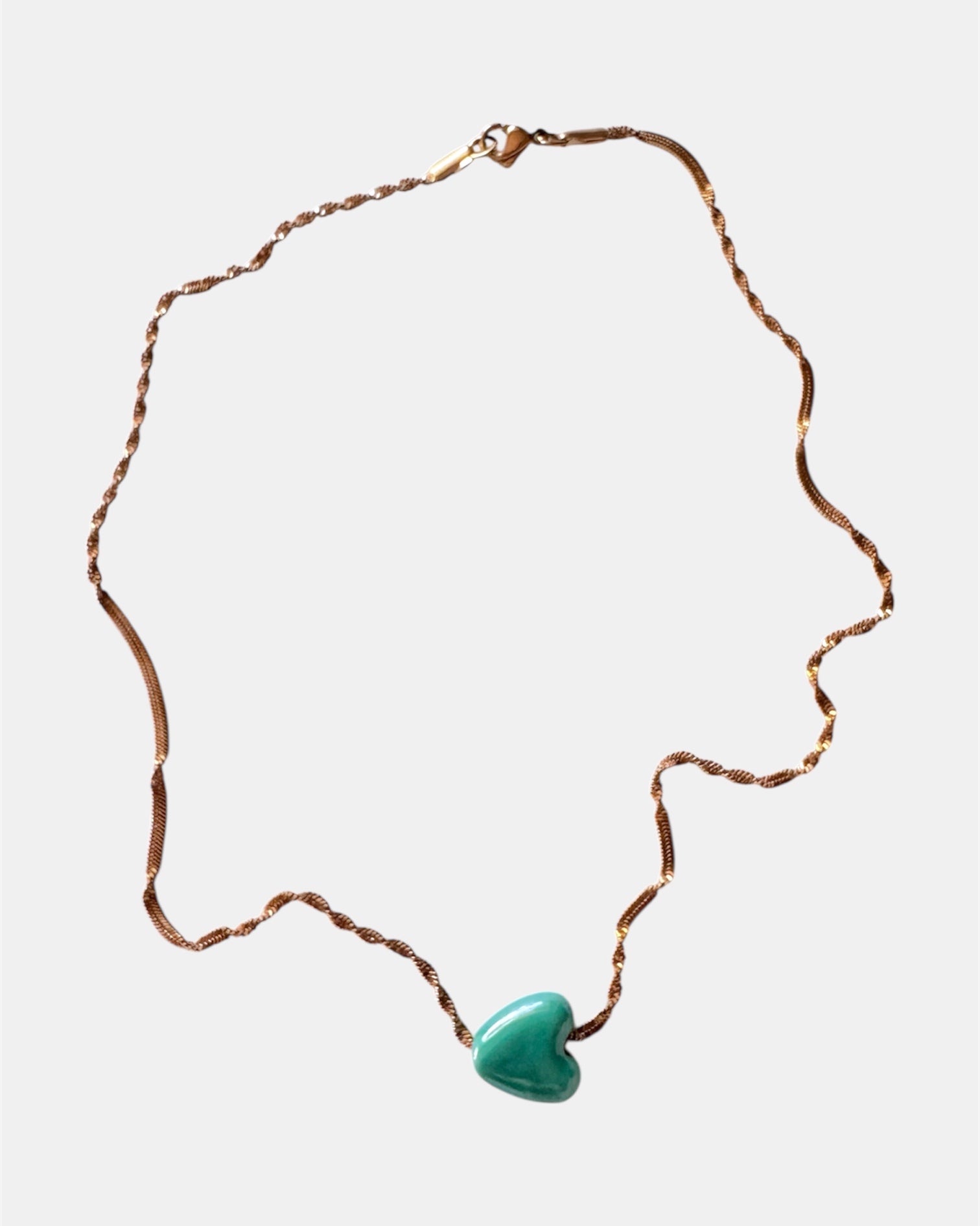 Rose gold chain necklace with a green heart charm