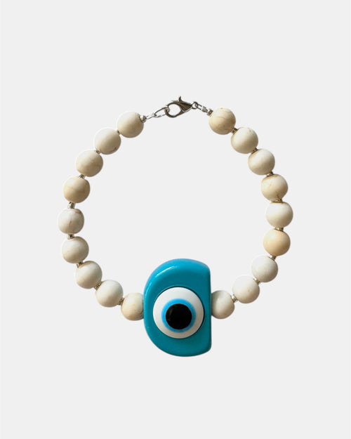 Silver bracelet with ecru beads and a turquoise evil eye charm