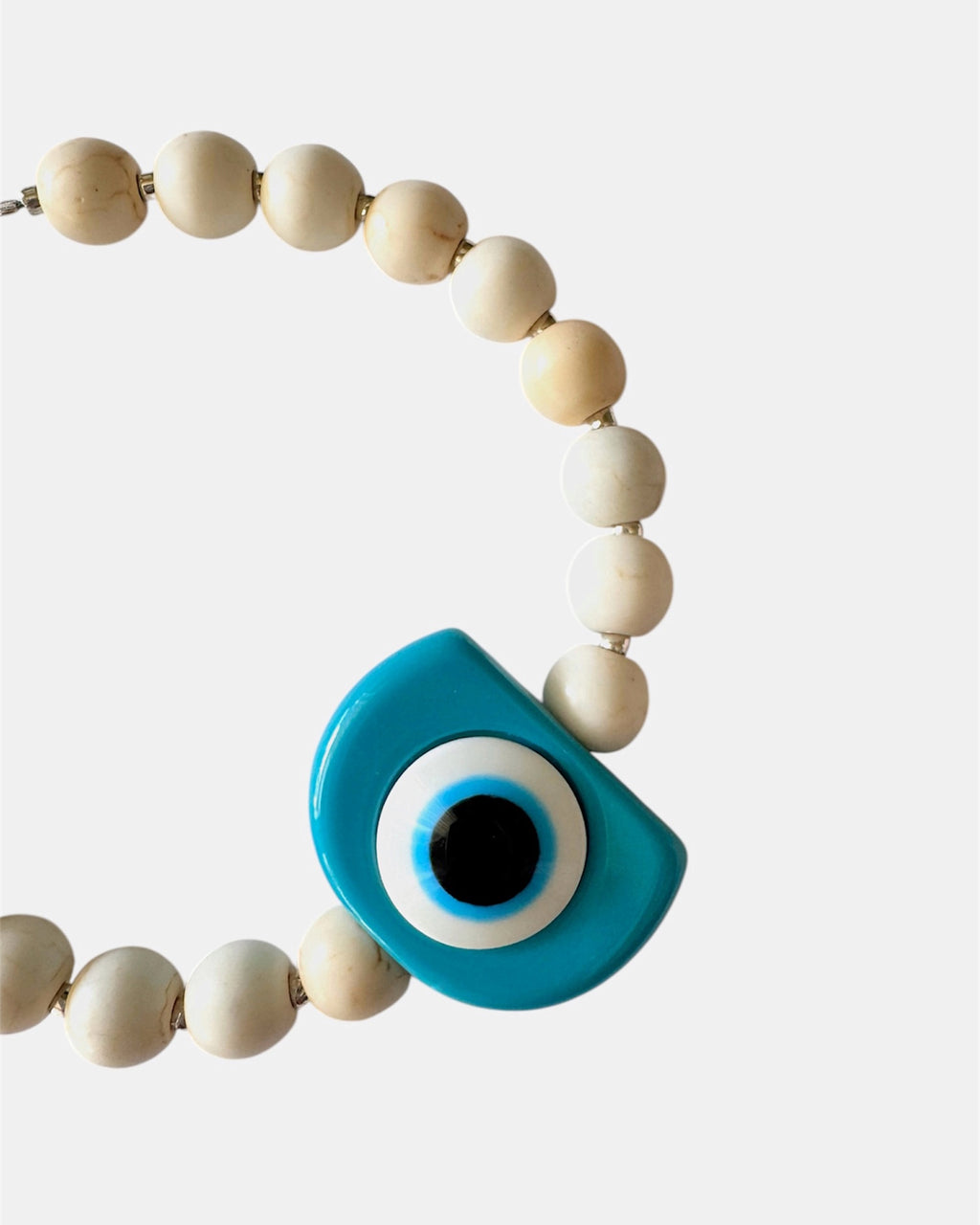 Silver bracelet with ecru beads and a turquoise evil eye charm
