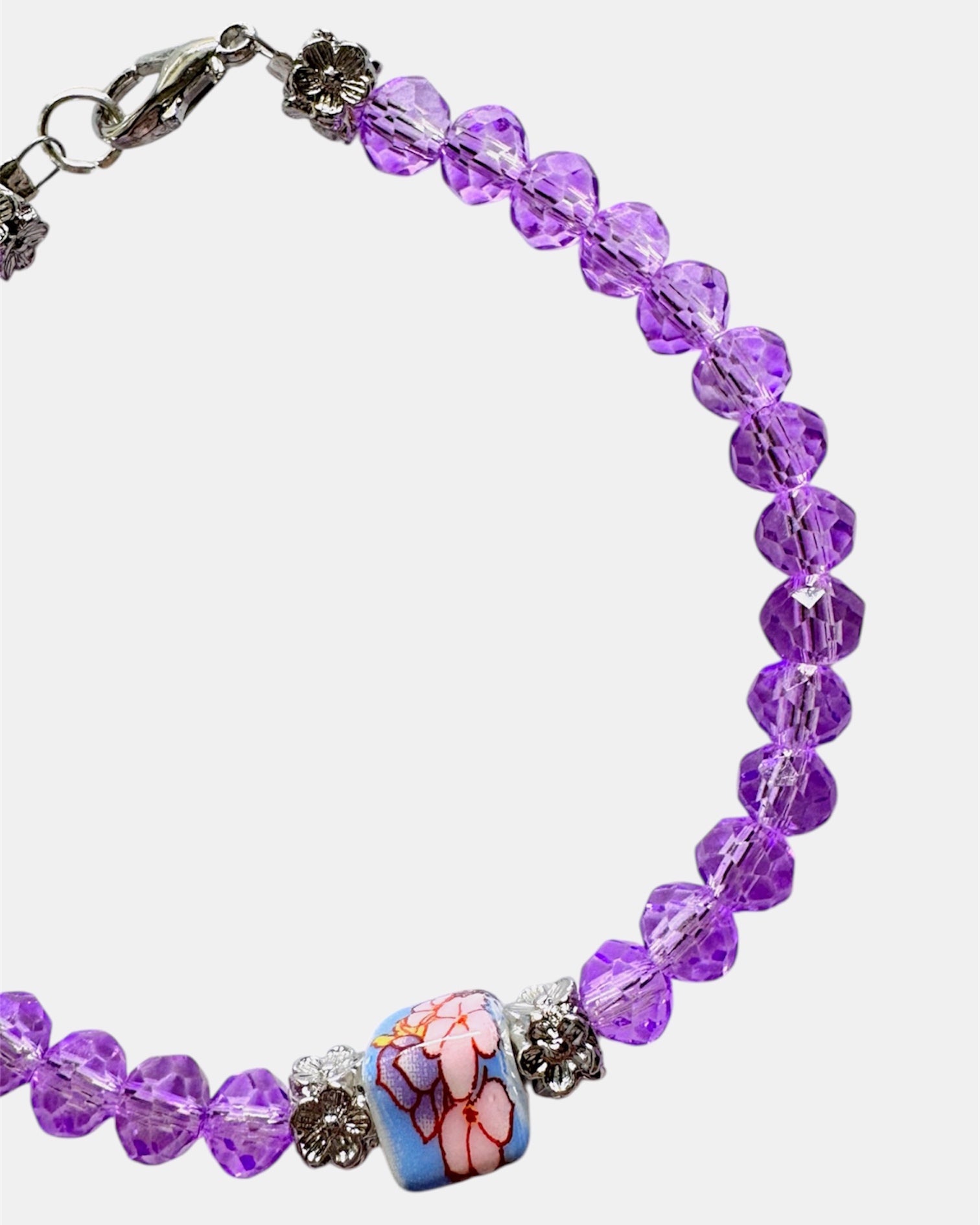 Stylish silver bracelet with purple crystal beads and a ceramic bead, elegant handmade jewelry piece for modern and chic looks