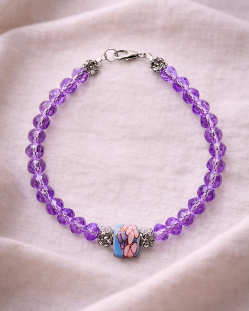 Stylish silver bracelet with purple crystal beads and a ceramic bead, elegant handmade jewelry piece for modern and chic looks