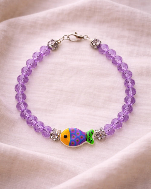 Elegant silver bracelet with purple crystal beads and fish charm, unique handmade jewelry inspired by the sea and modern style