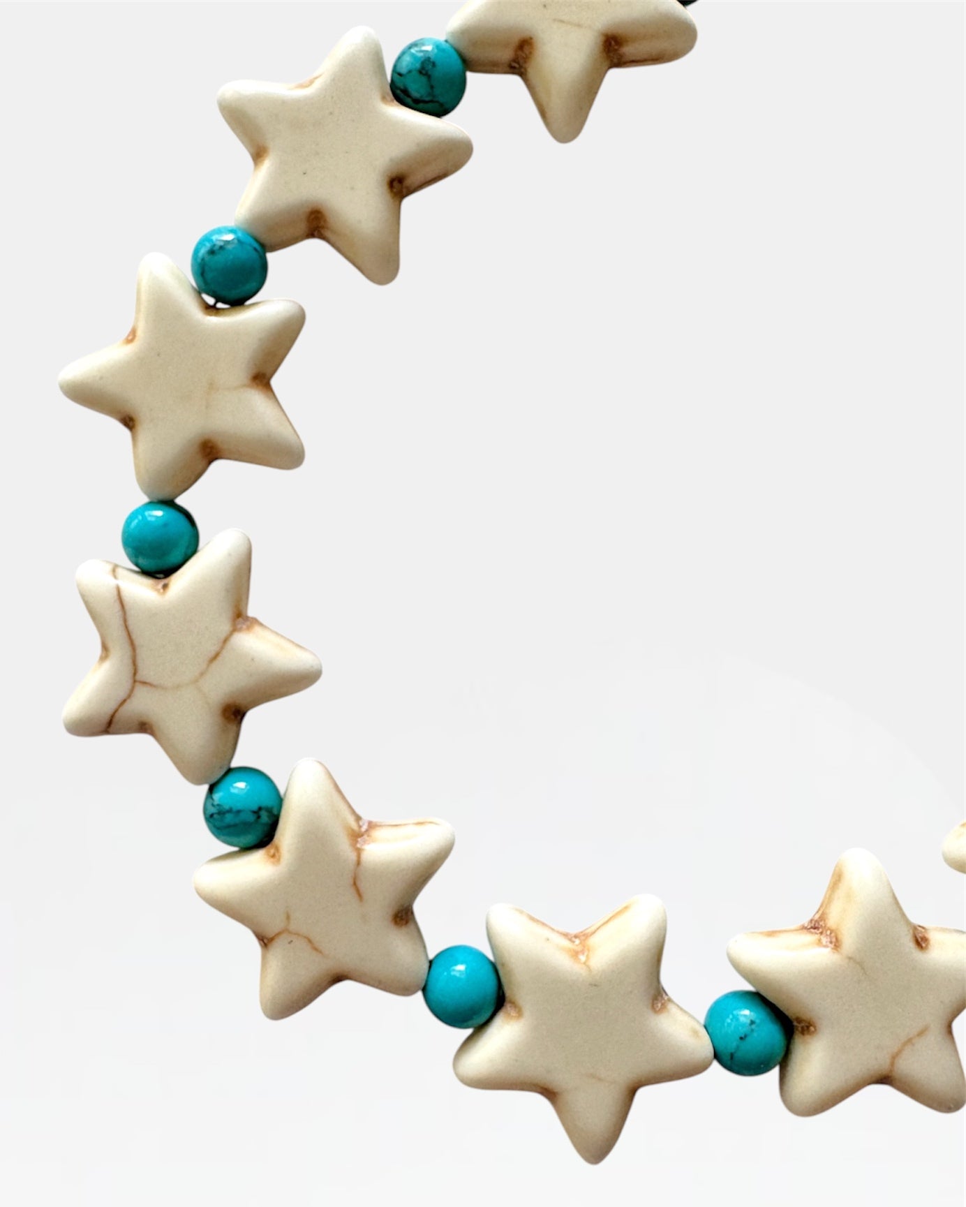 Silver bracelet with stars and turquoise beads.