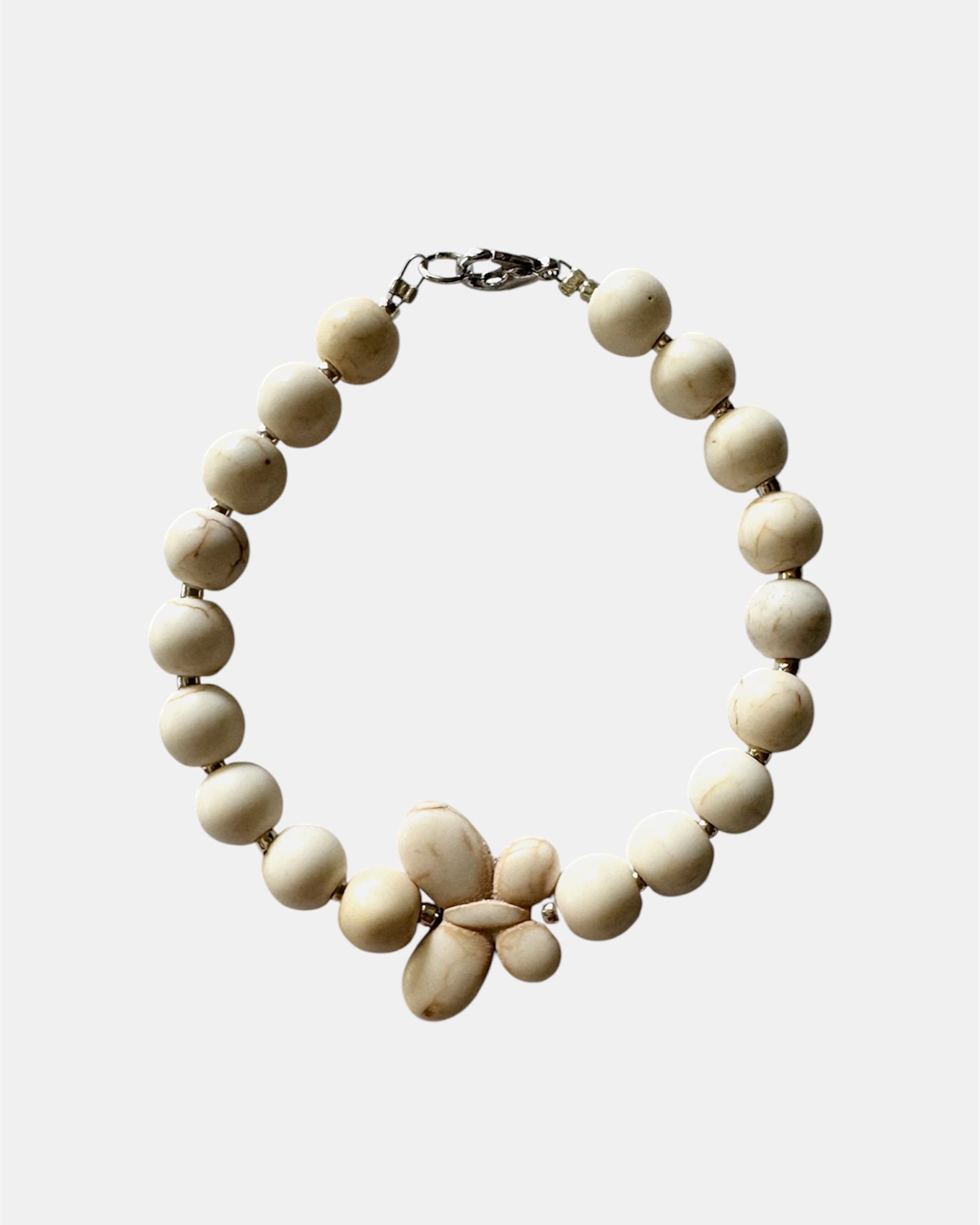Silver bracelet with ecru beads and butterfly charm in elegant delicate style