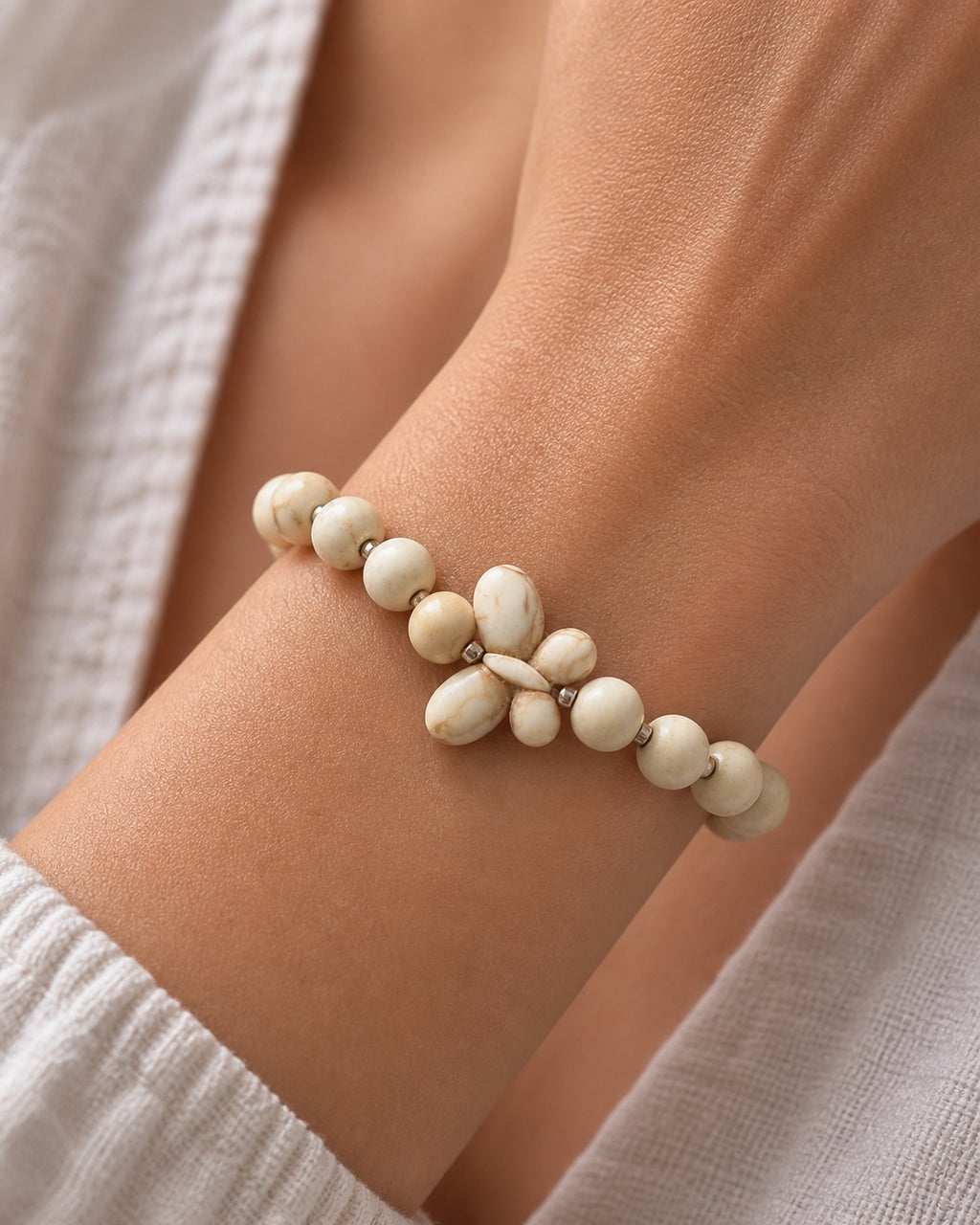 Silver bracelet with ecru beads and butterfly charm in elegant delicate style
