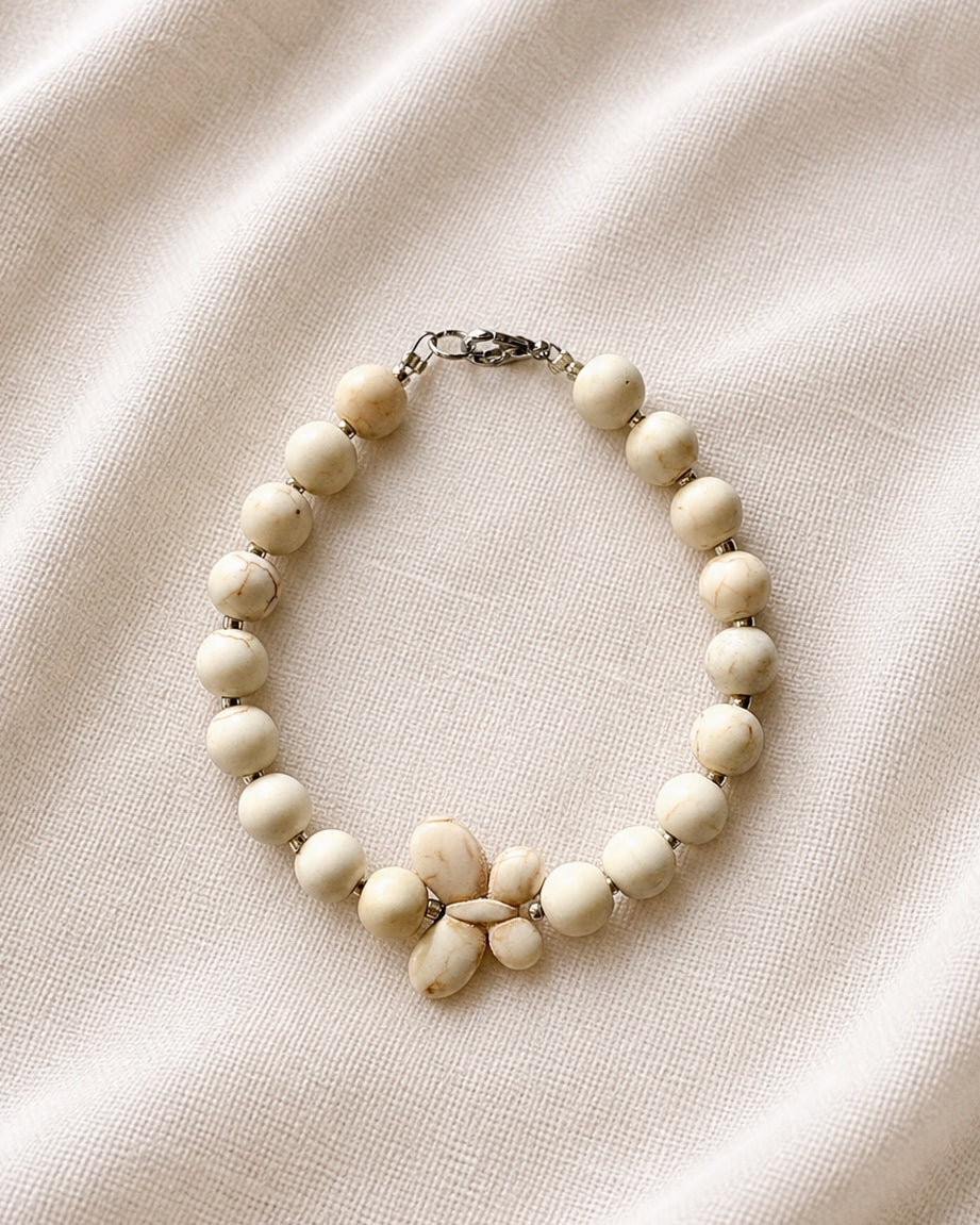 Silver bracelet with ecru beads and butterfly charm in elegant delicate style