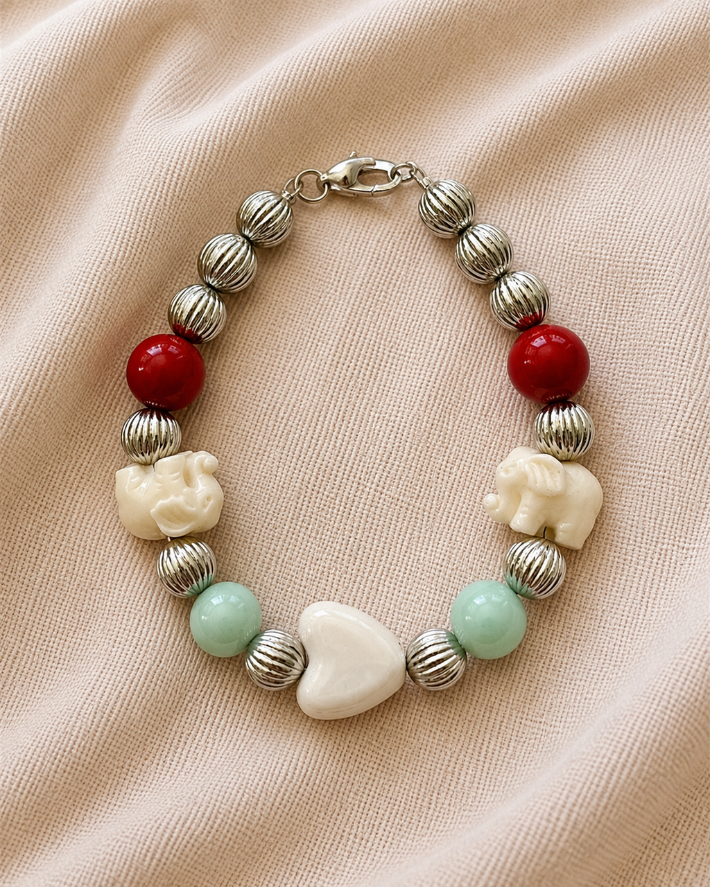 Silver bracelet with elephant charms and heart detail in elegant symbolic style