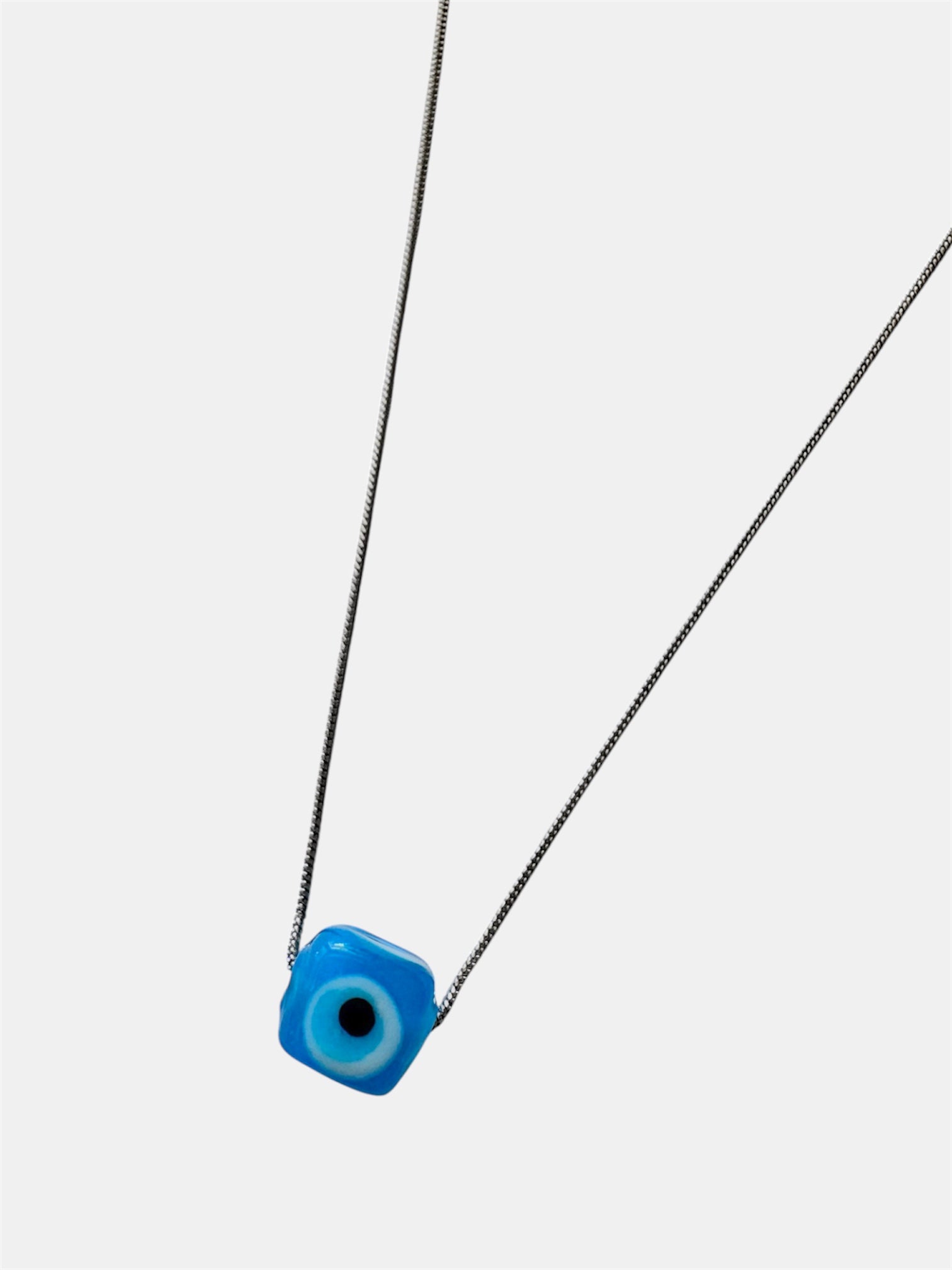 Silver chain necklace with a blue glass evil eye charm