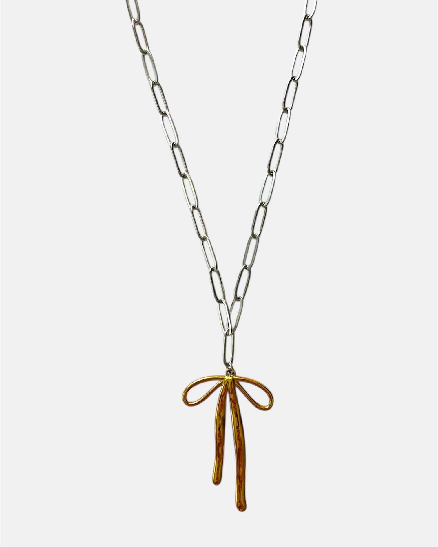 Silver chain necklace with a gold bow pendant