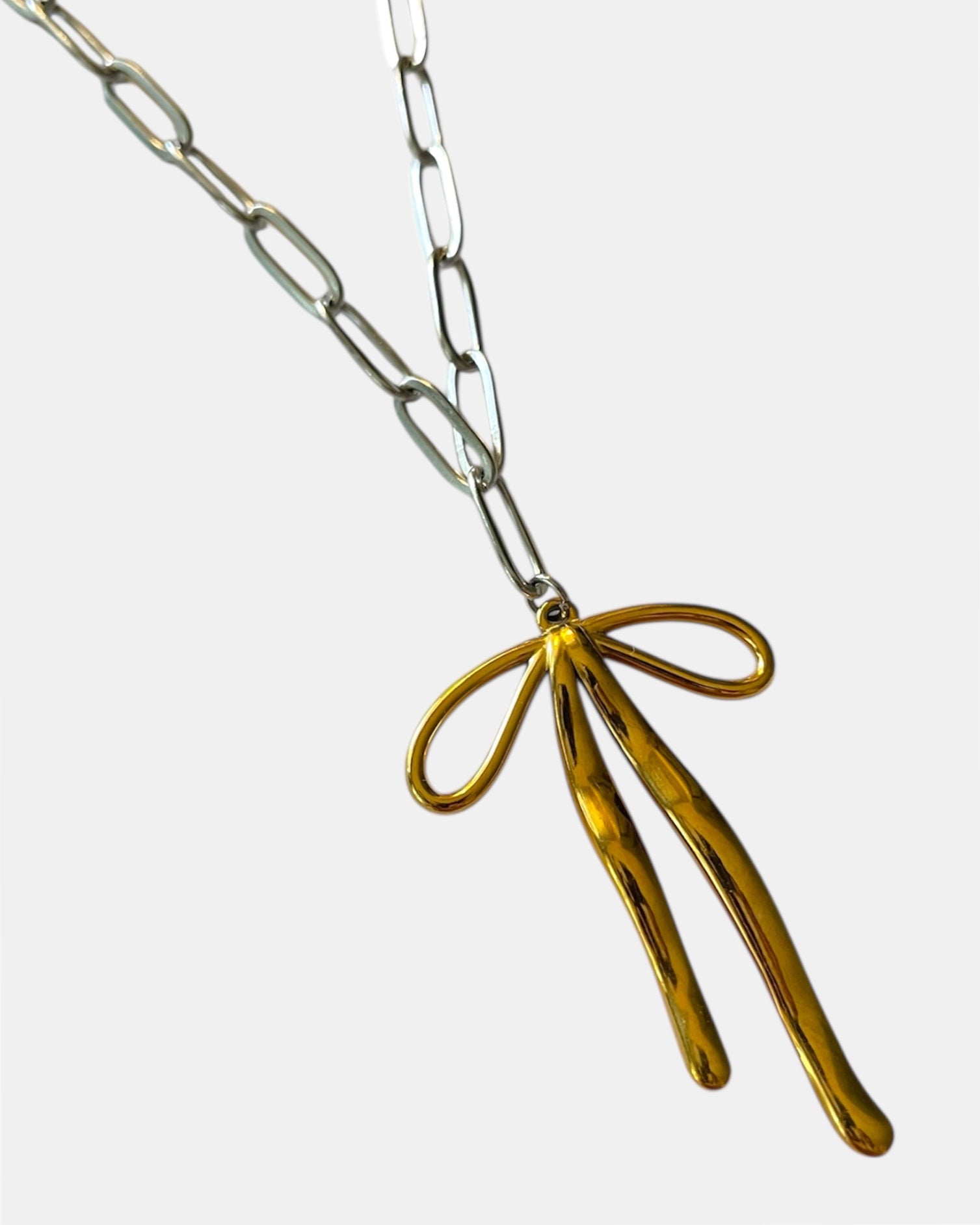 Silver chain necklace with a gold bow pendant