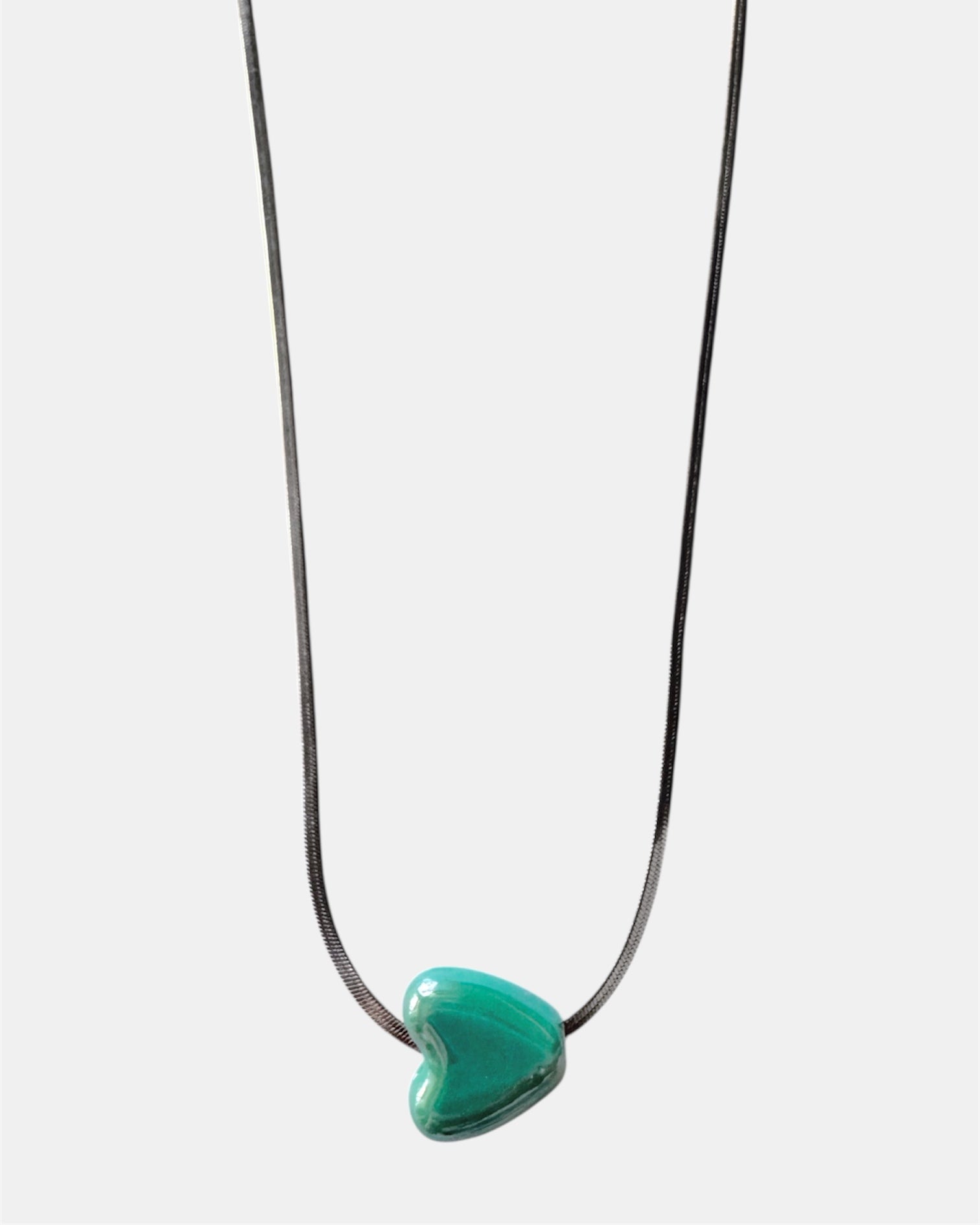 Silver chain necklace with a green heart charm