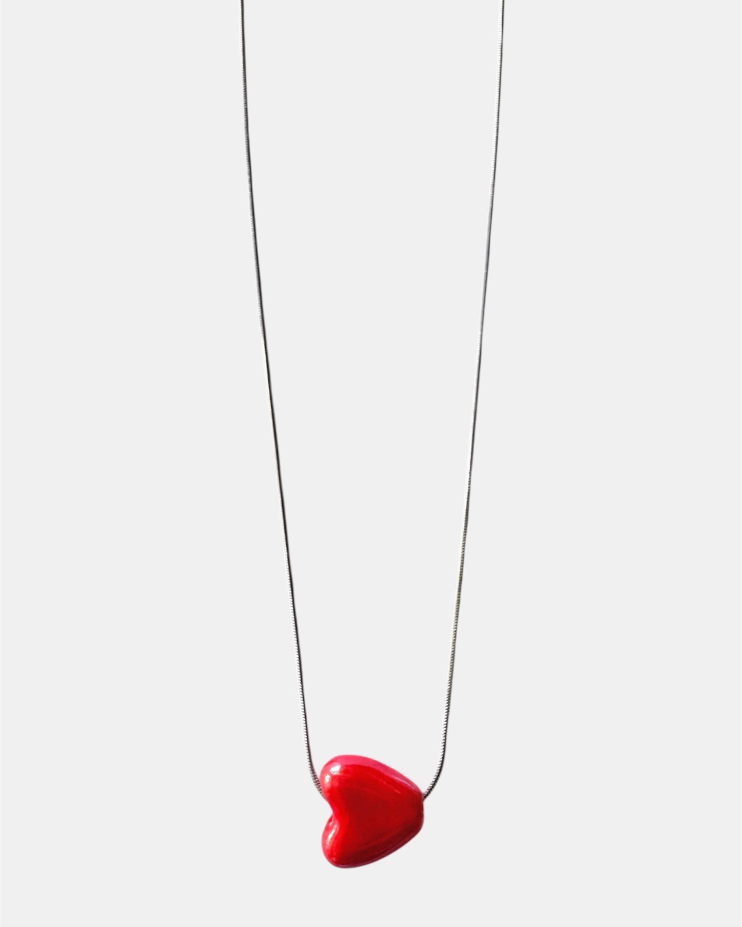 Silver chain necklace with a red heart charm