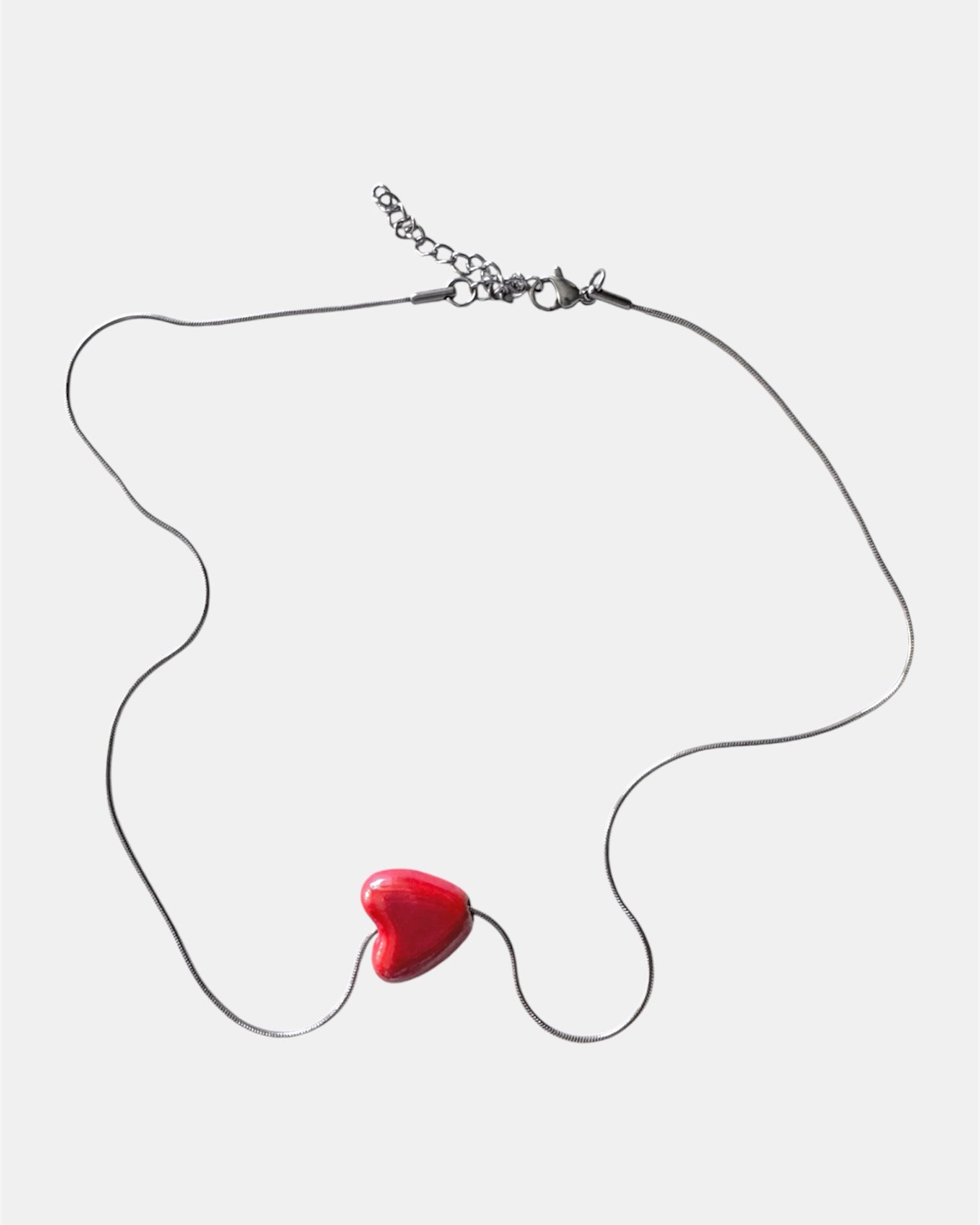 Silver chain necklace with a red heart charm