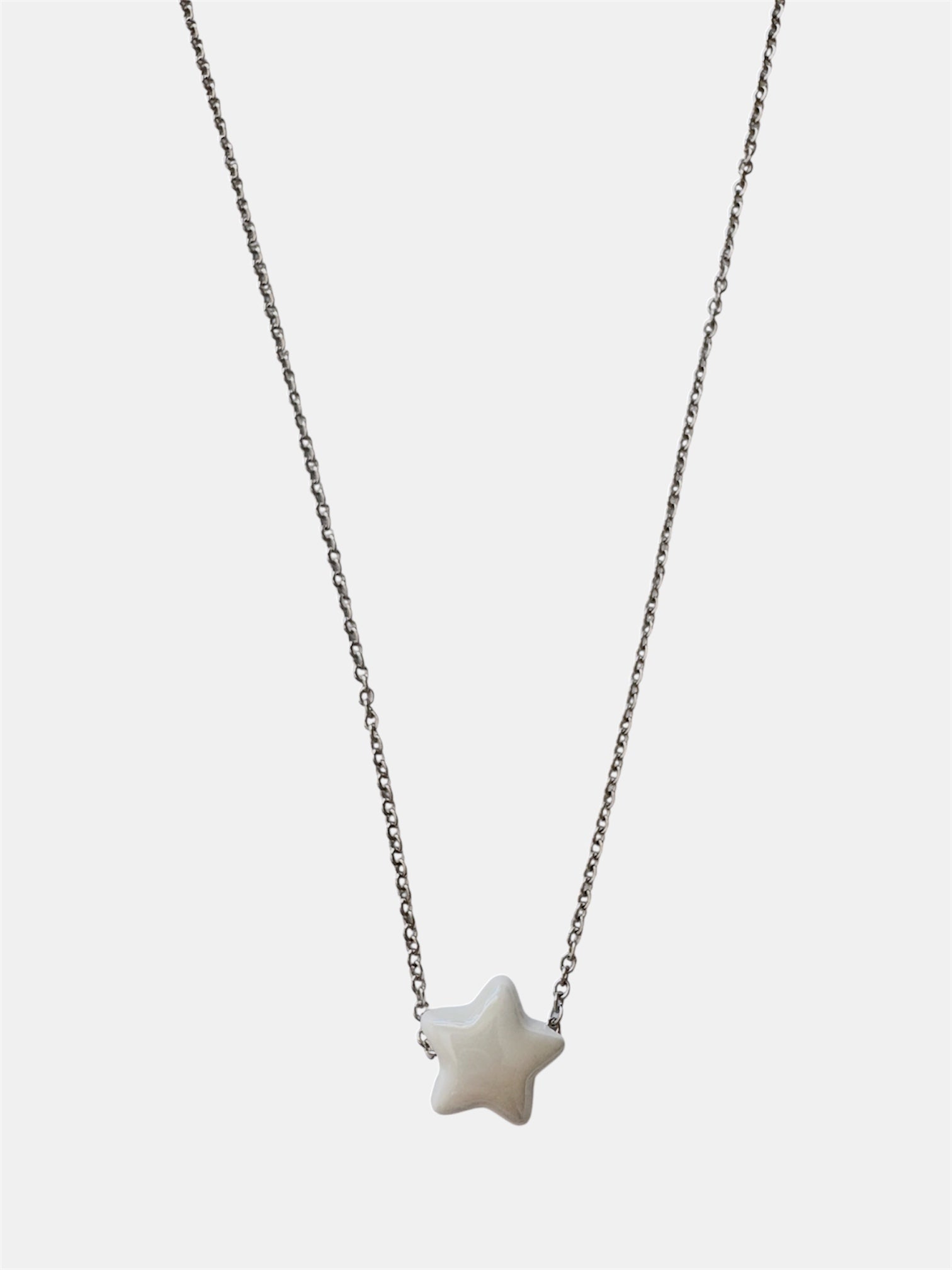 Silver chain necklace with a white ceramic star charm