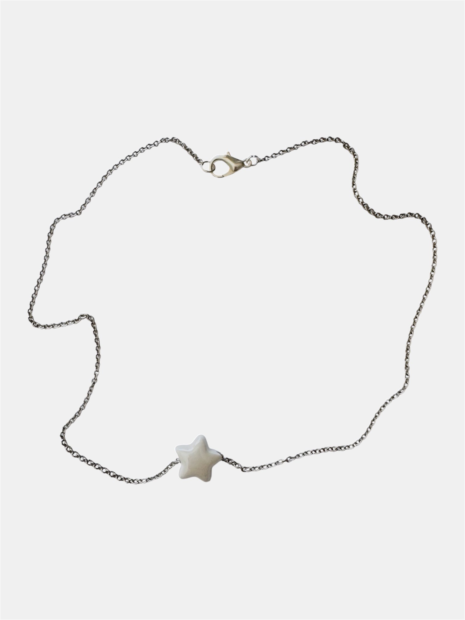 Silver chain necklace with a white ceramic star charm