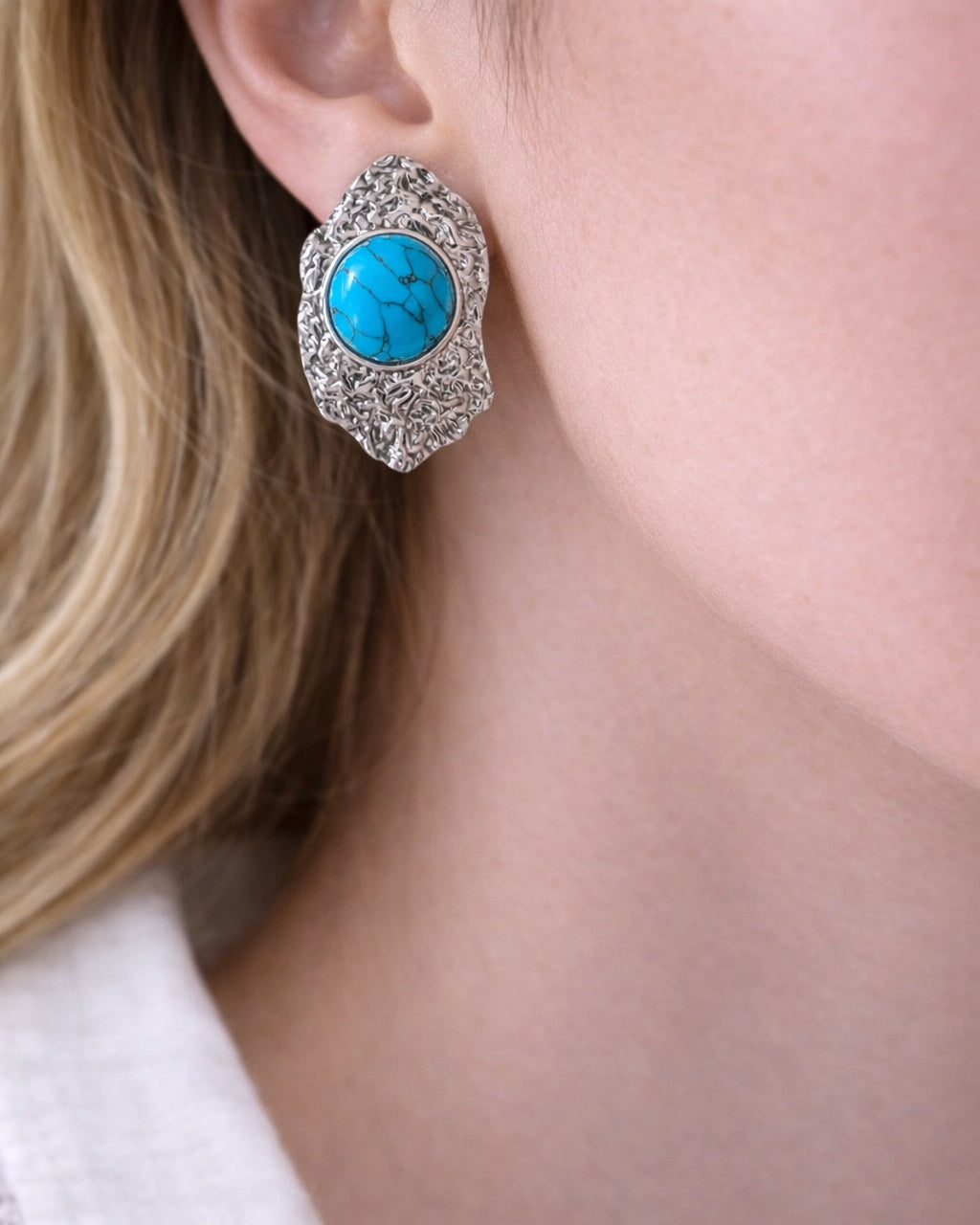 Silver dangling earrings with teal stone.