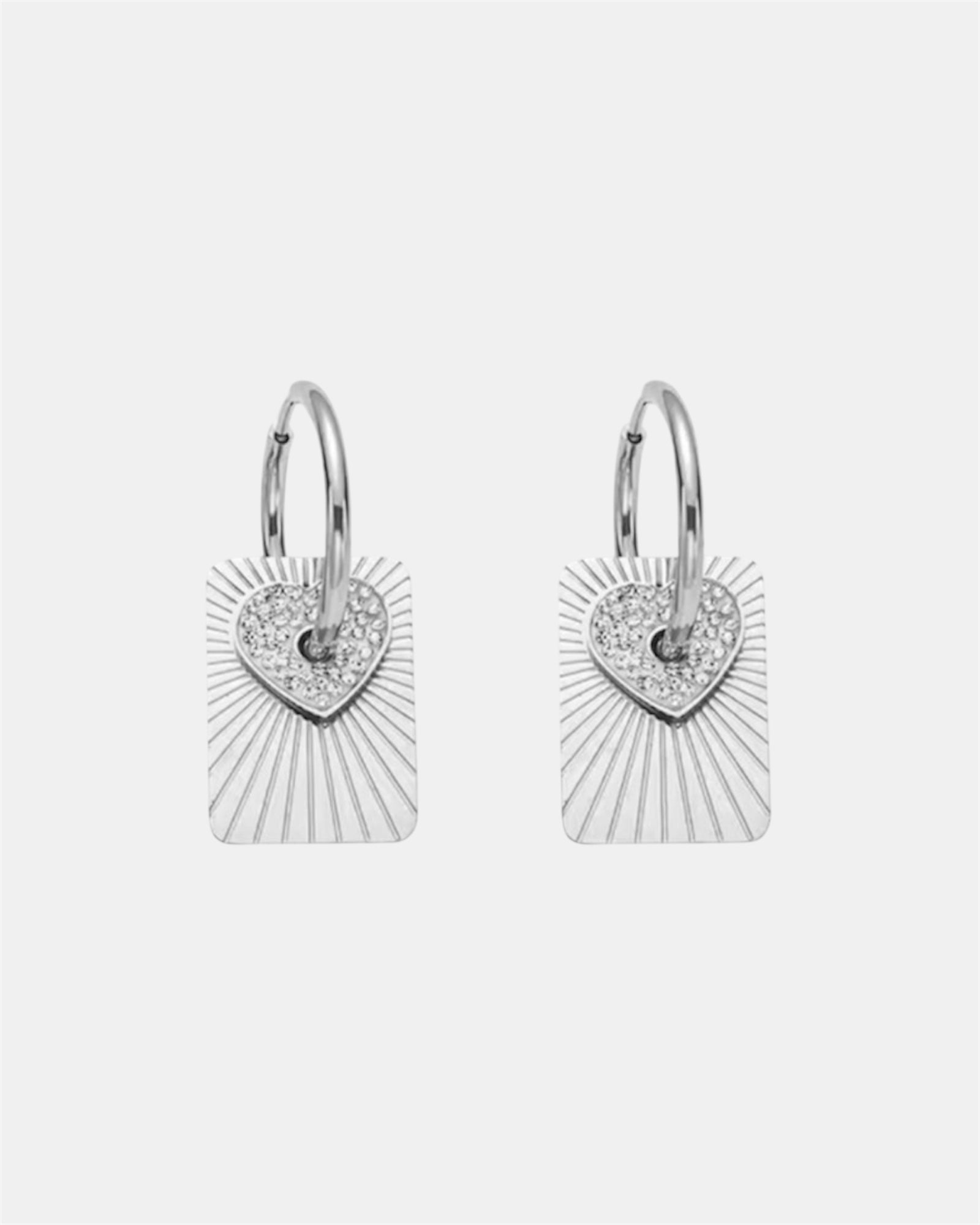 Silver hoop earrings with a heart charm and a flat pendant