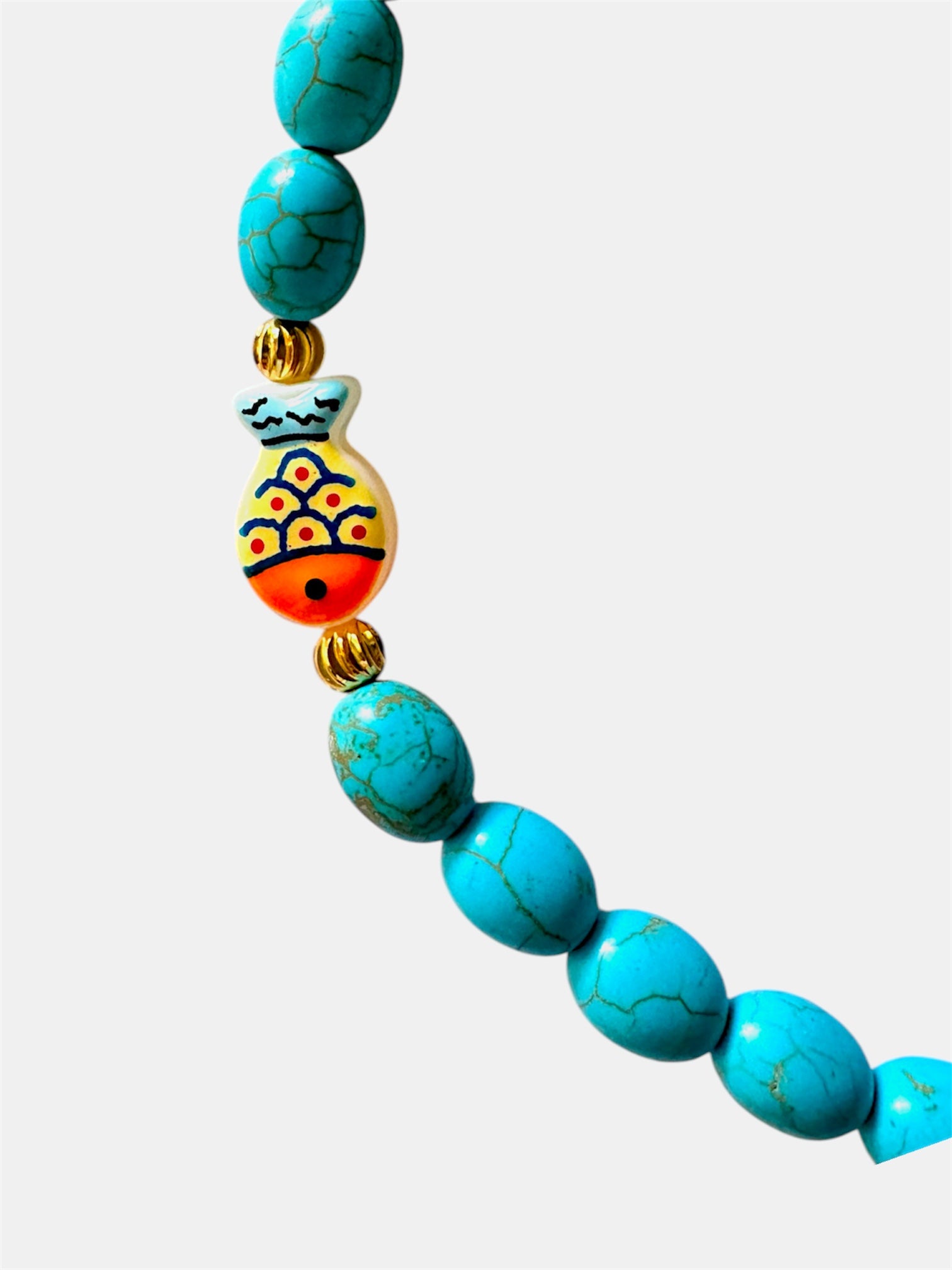 Turquoise necklace featuring a decorative fish charm for a playful and ocean-inspired accessory