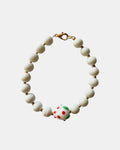 White beaded bracelet with a ceramic strawberry charm