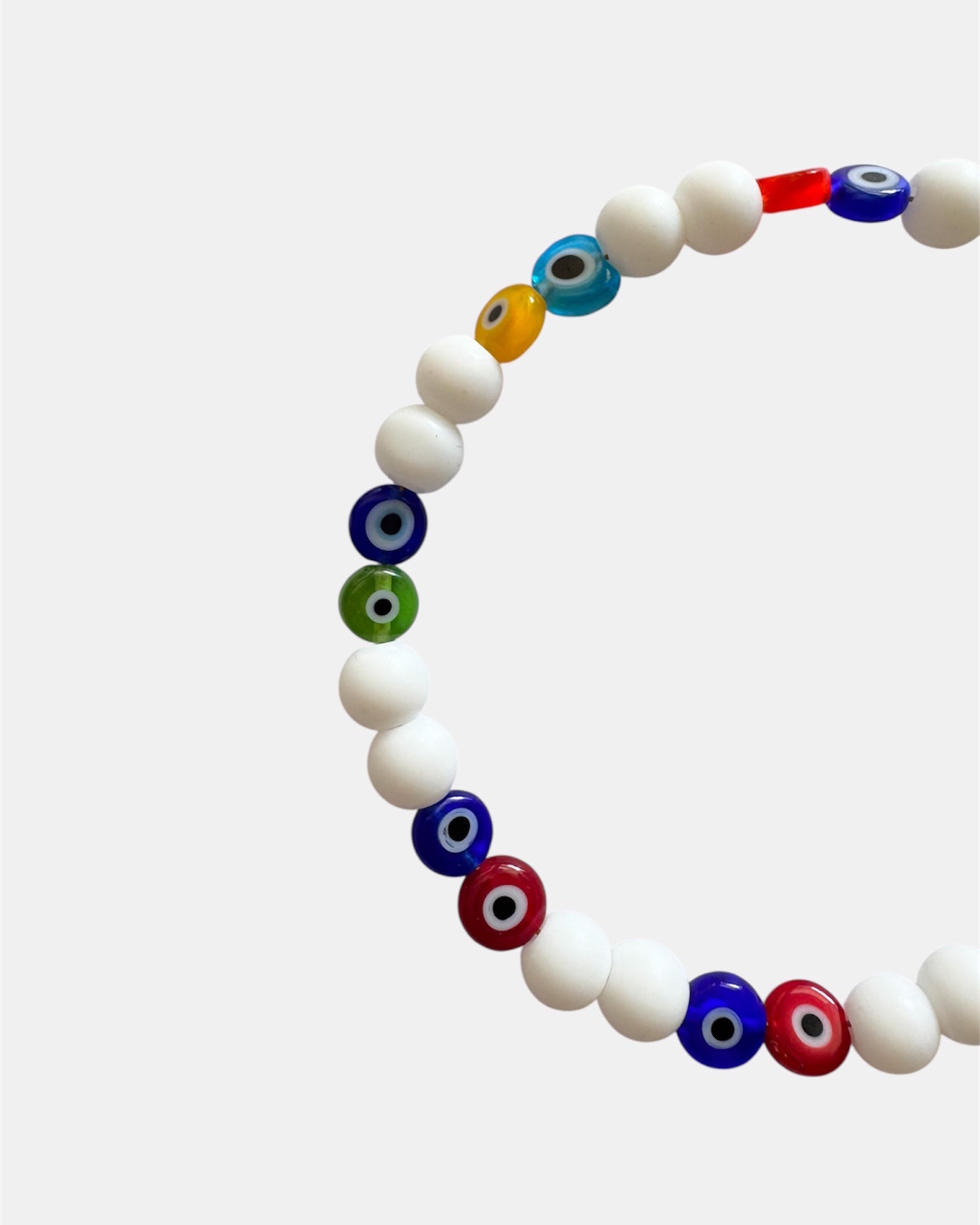Bracelet with white beads and multicolored evil eye beads on a white background