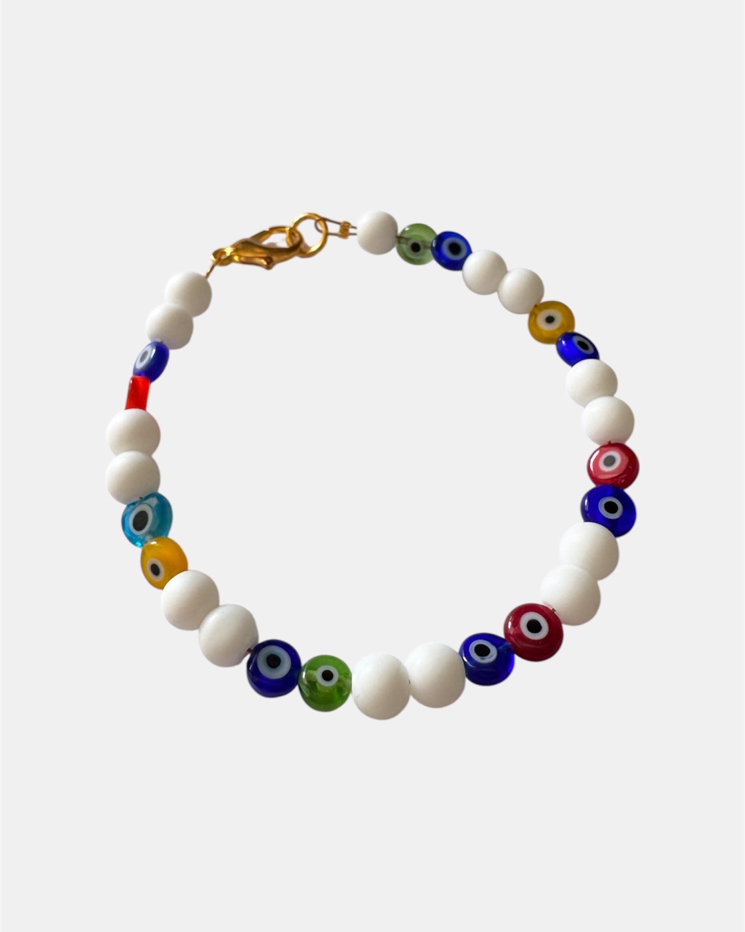 Bracelet with white beads and multicolored evil eye beads on a white background