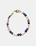 Bracelet with white beads and multicolored evil eye beads on a light gray background