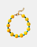 Bracelet with yellow beads and a gold clasp on a white background