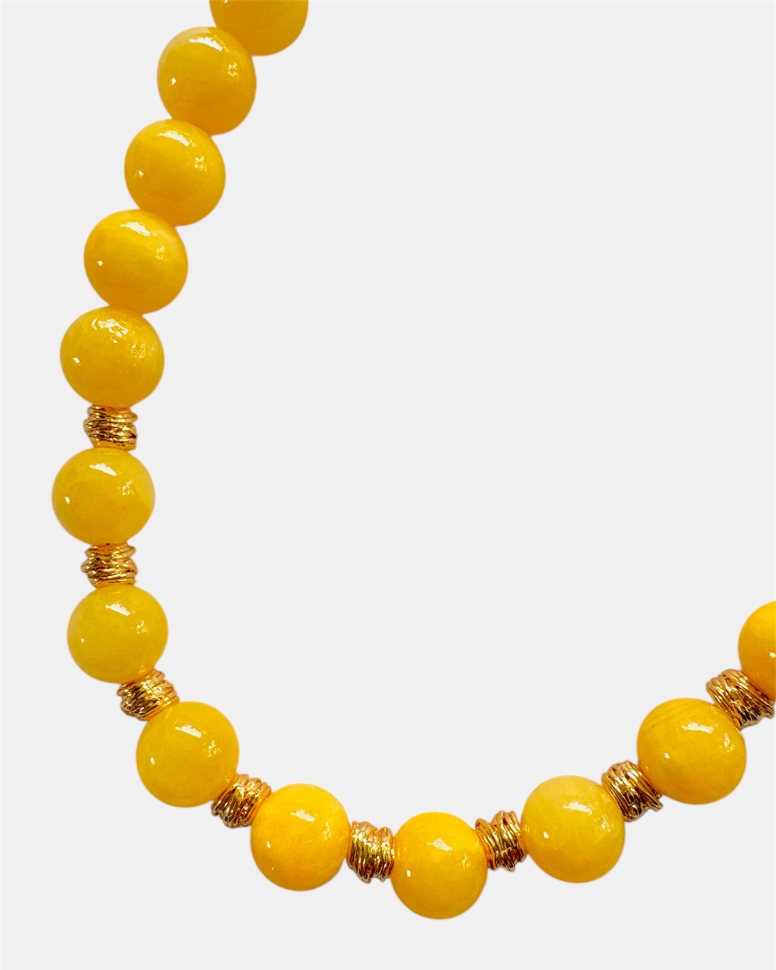 Yellow beaded necklace with gold accents on a white background